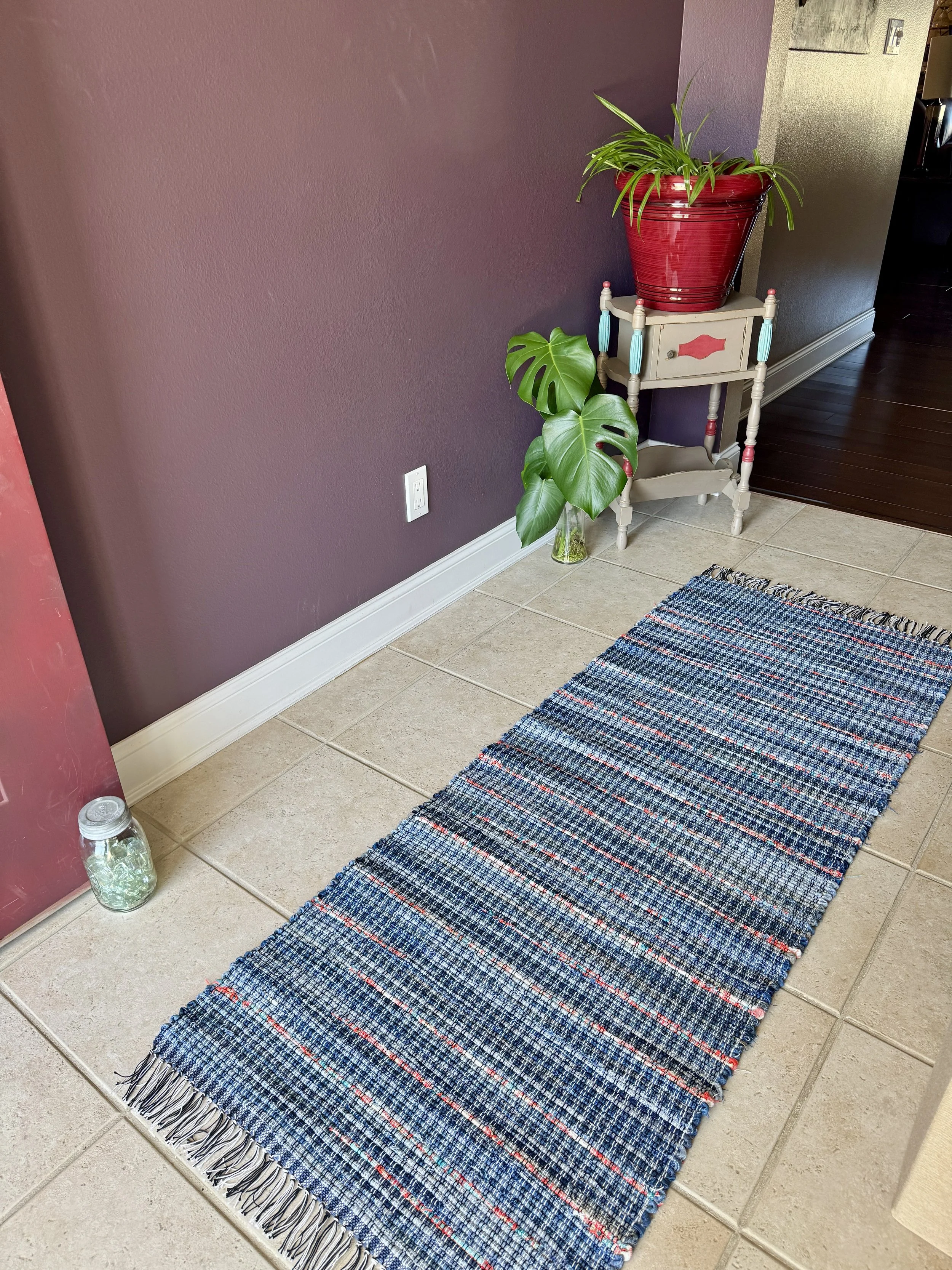 Displayed handcrafted rag rug in entryway showing pattern
