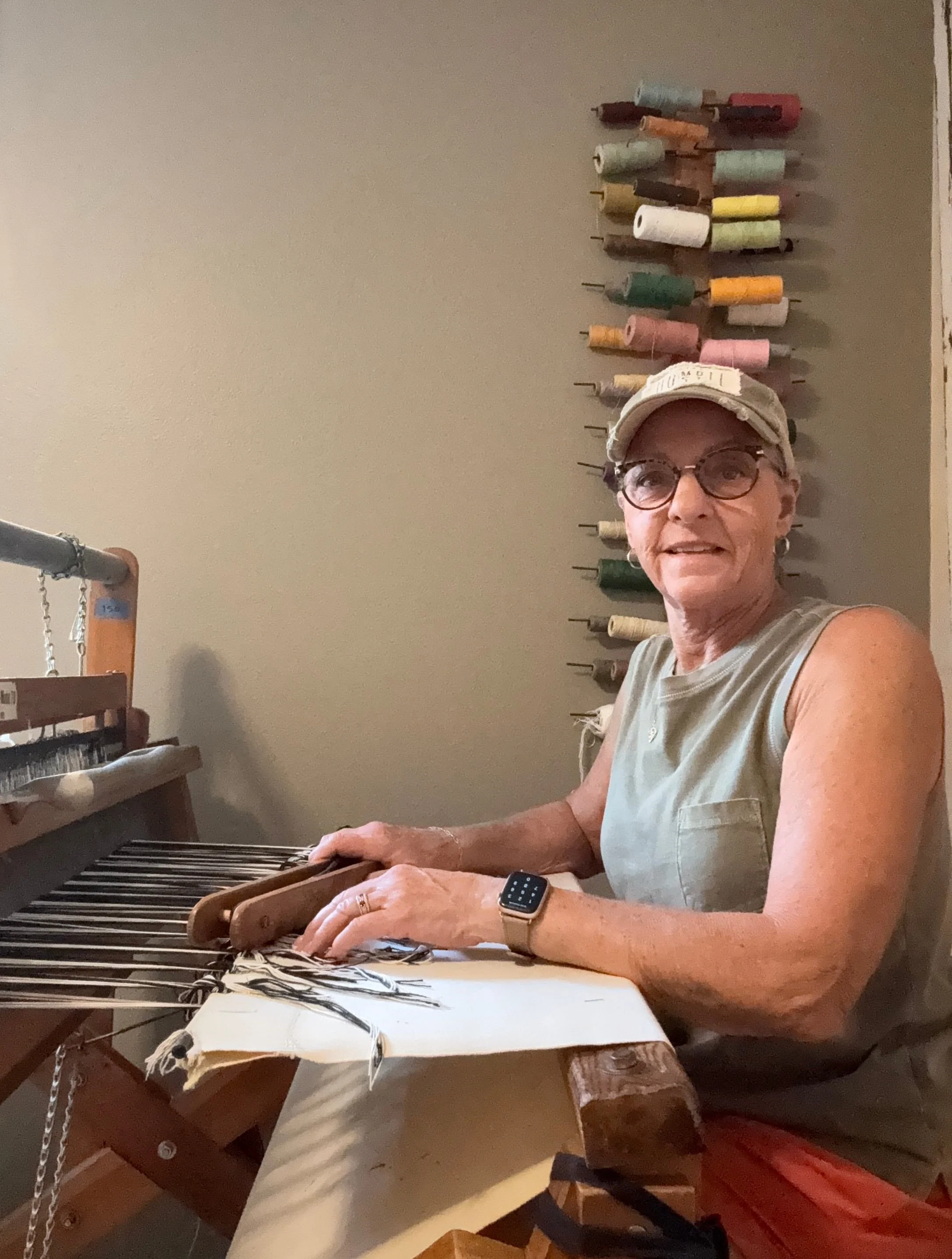 Terry weaving a handmade rag rug on wooden floor loom in her home