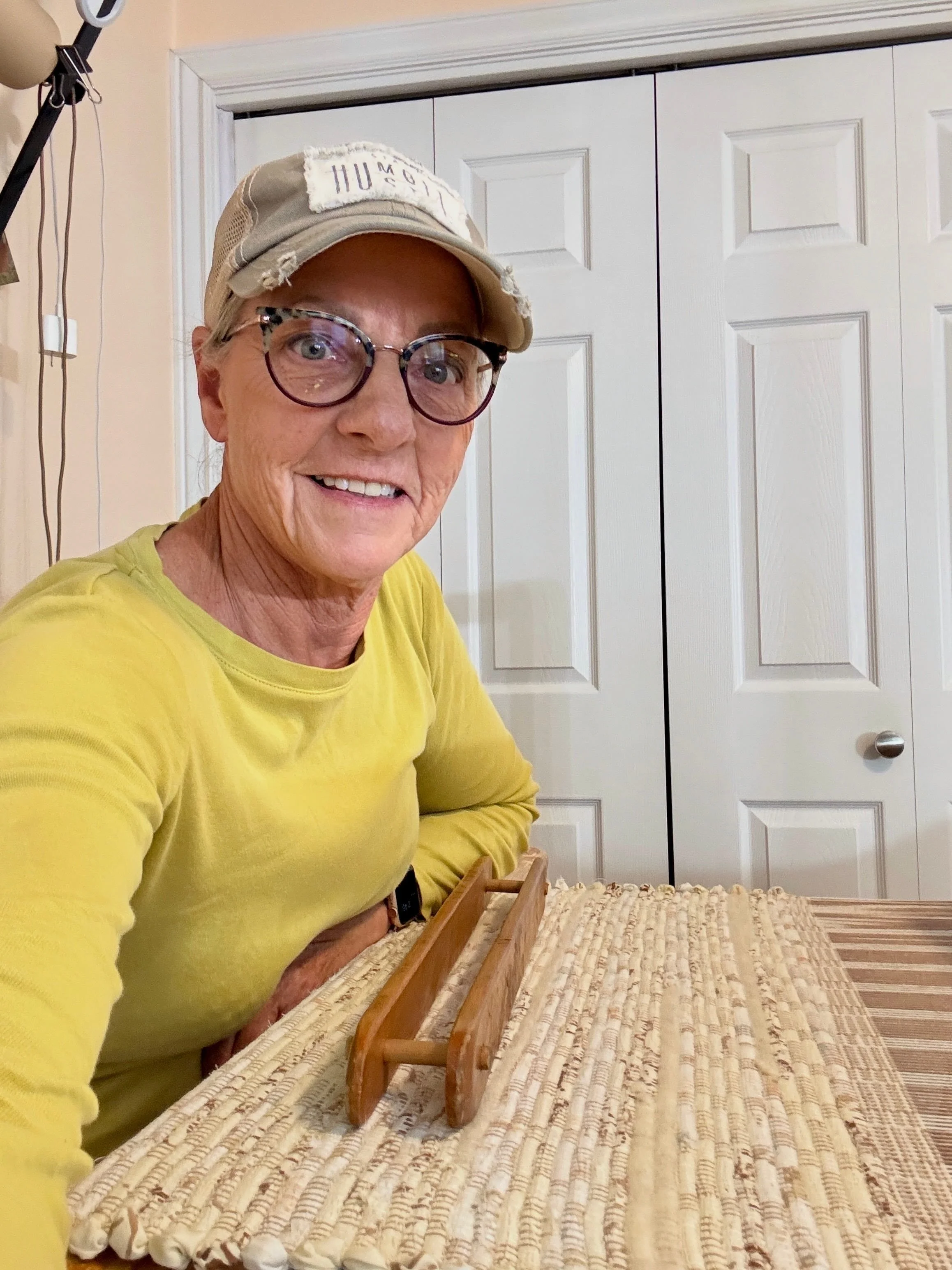 Terry weaving a handwoven rag rug on a wooden floor loom