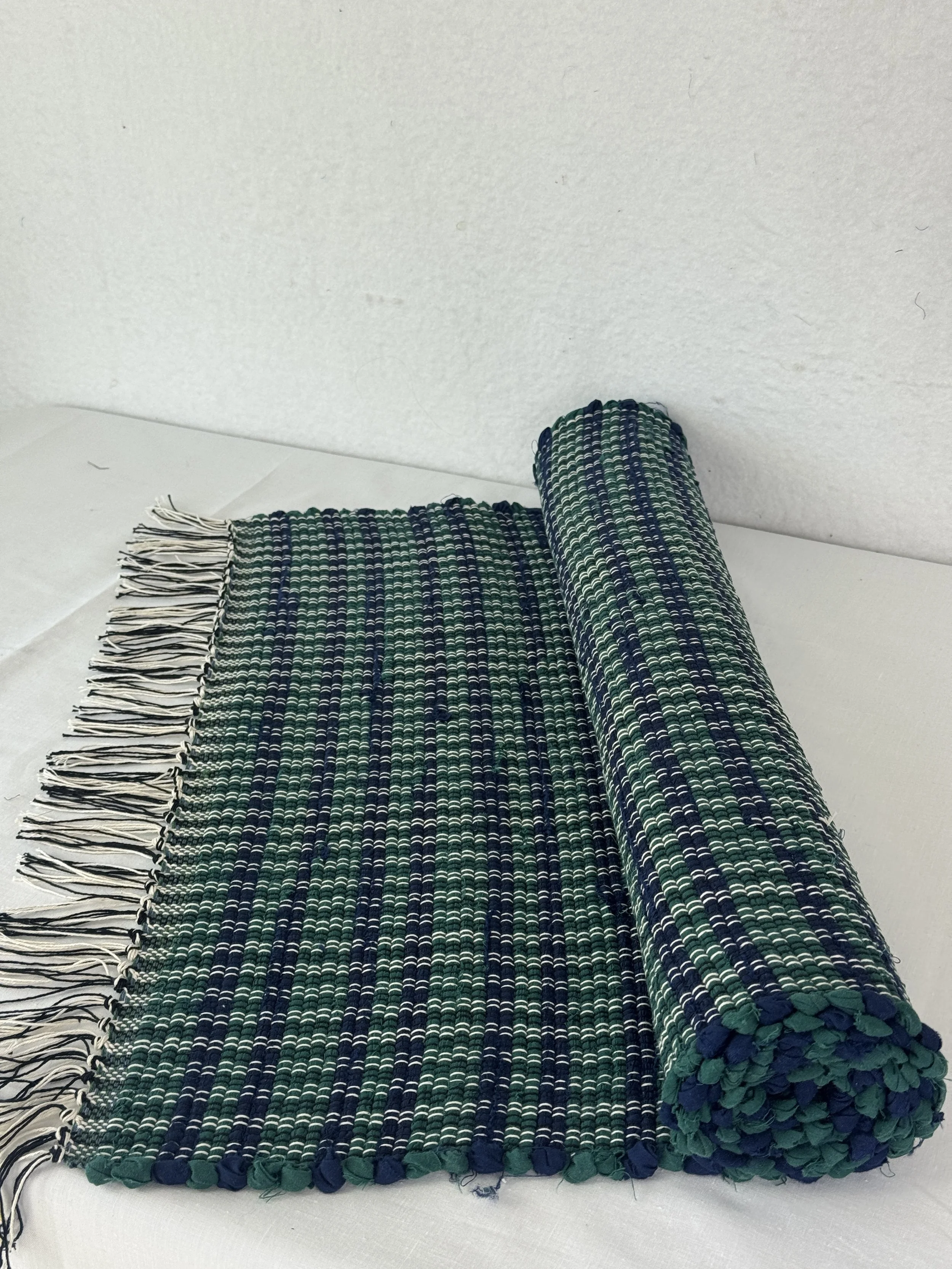 Handwoven navy and green rag rug made with recycled materials