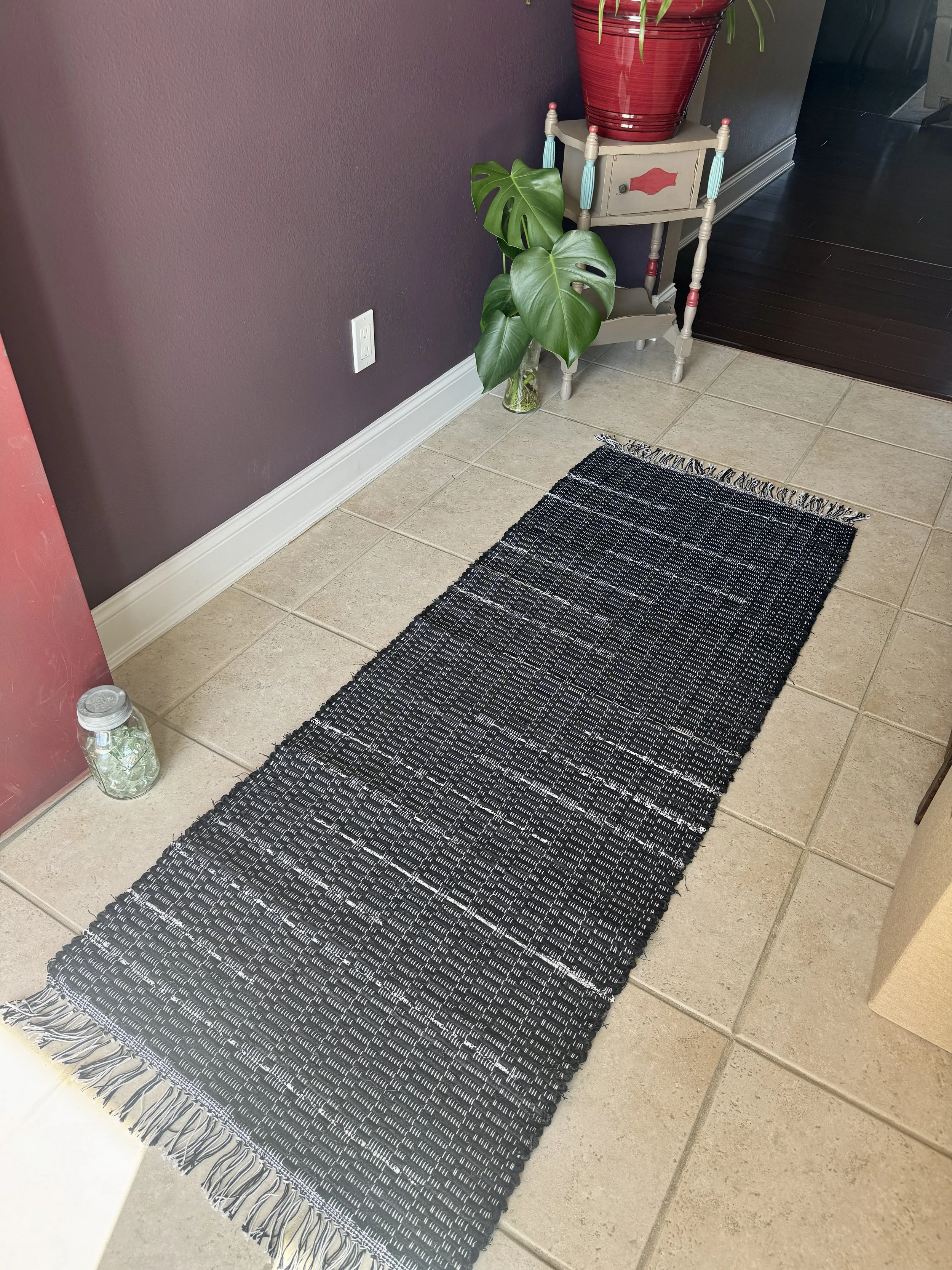 Displayed handcrafted rag rug in entryway showing pattern