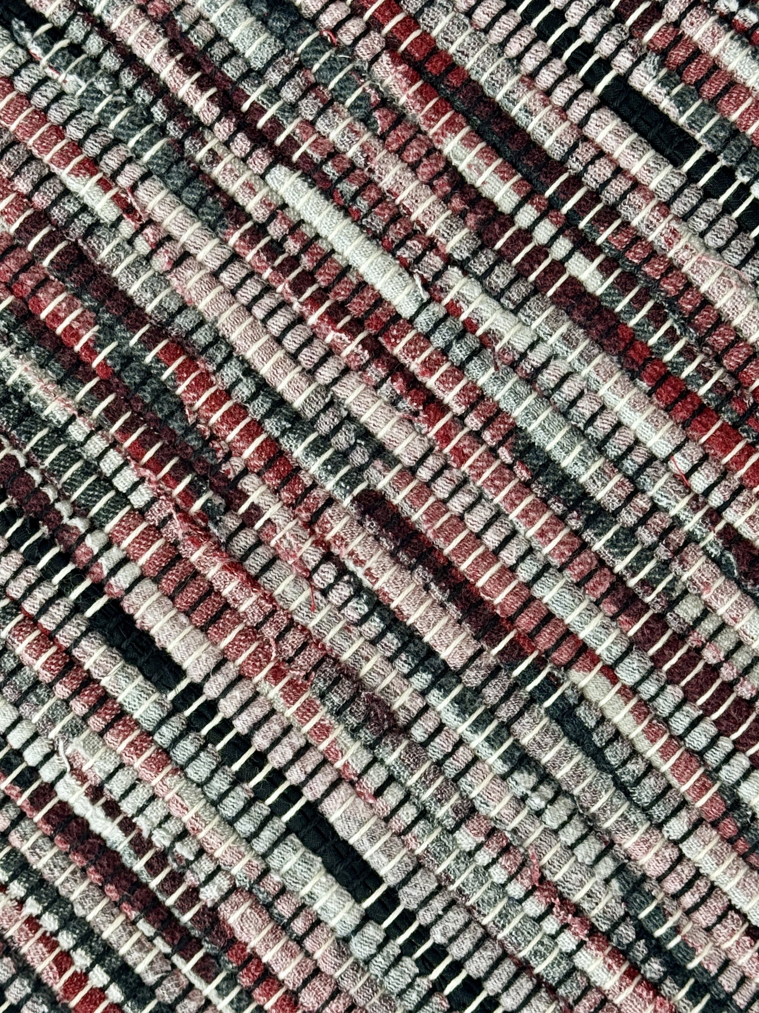 Up close handmade rag rug of upcycled cotton textiles showing texture and weave