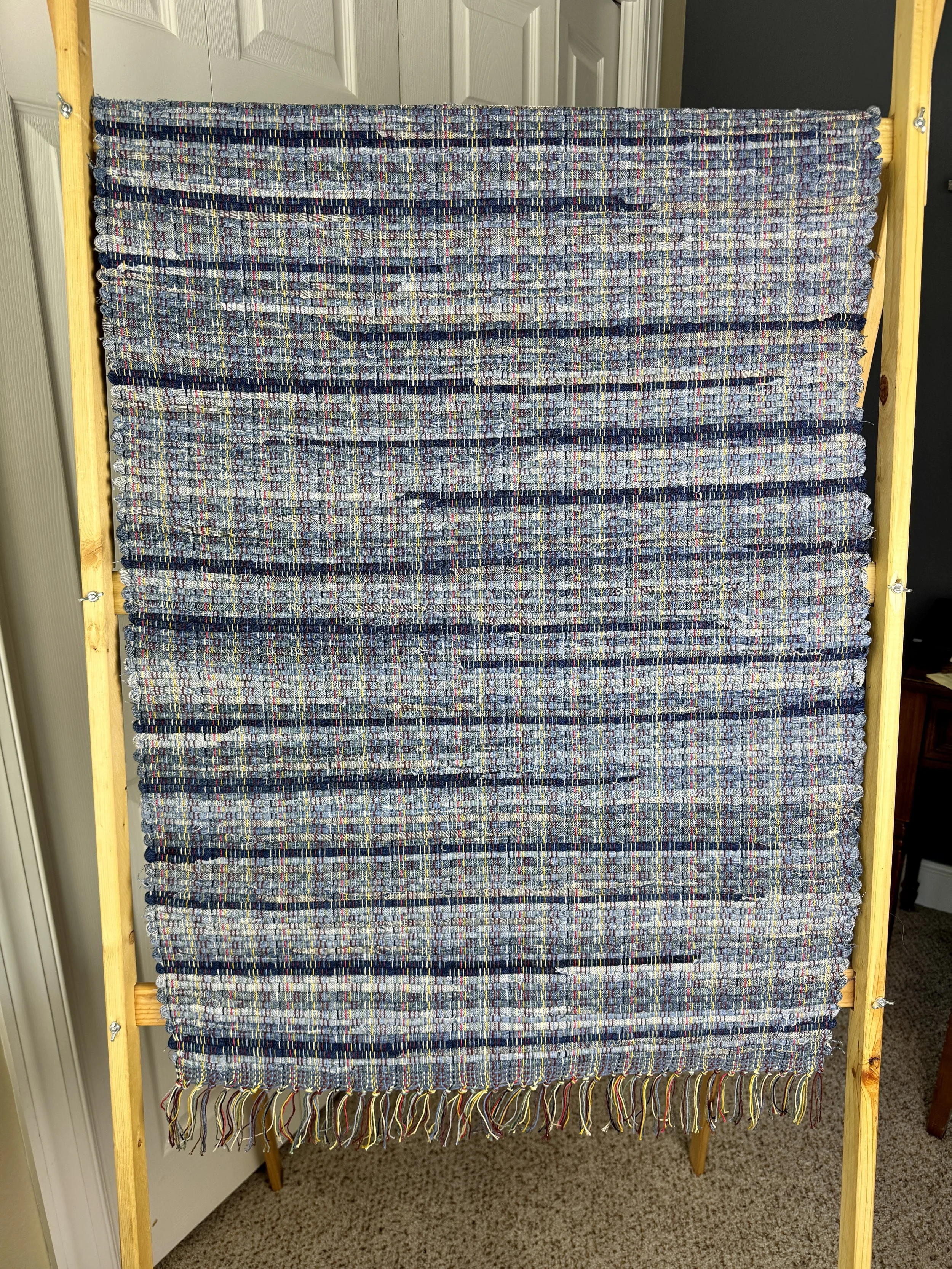 Hanging woven rag rug showing pattern