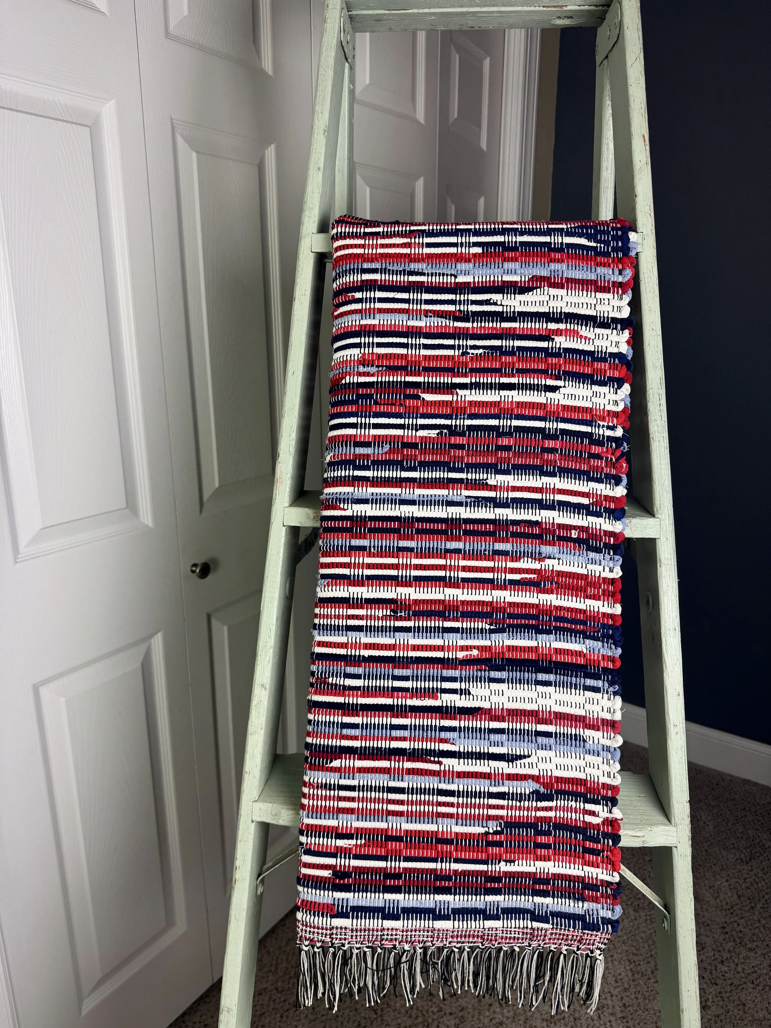 Hanging handmade recycled cotton  rag rug showing pattern and fringe