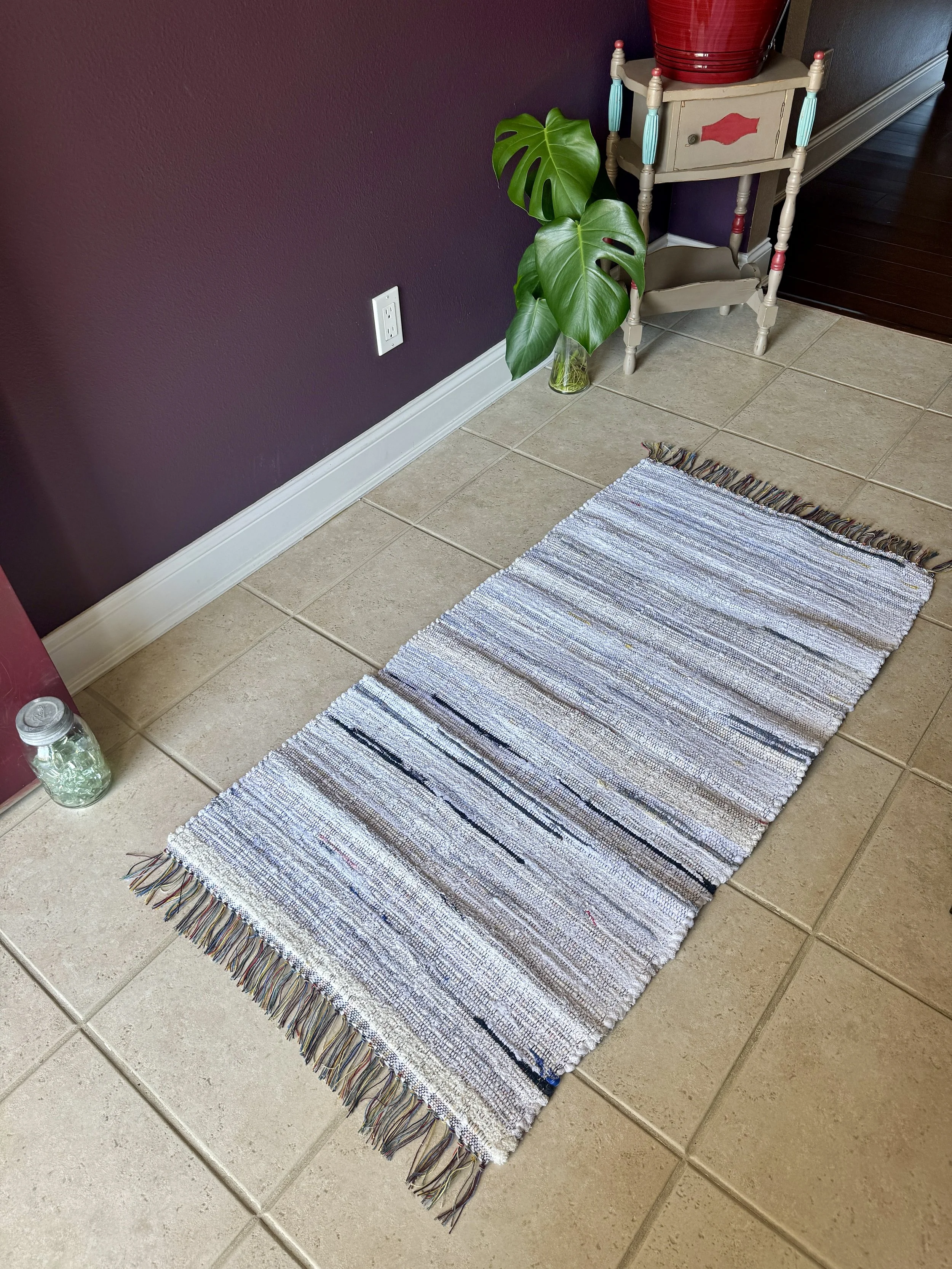 Displayed handcrafted rag rug in entryway showing pattern
