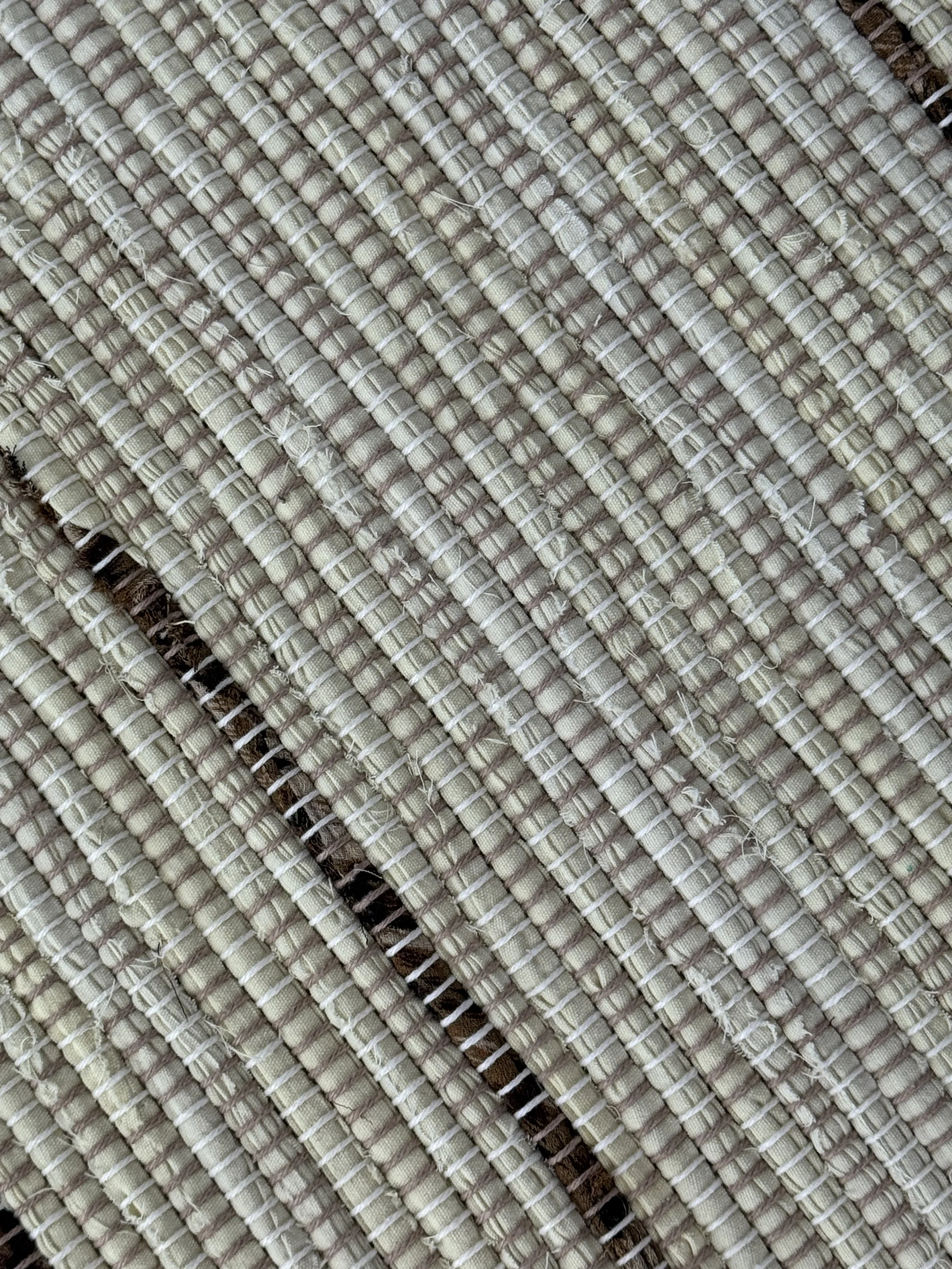 Handmade rag rug close-up showing texture and fringe