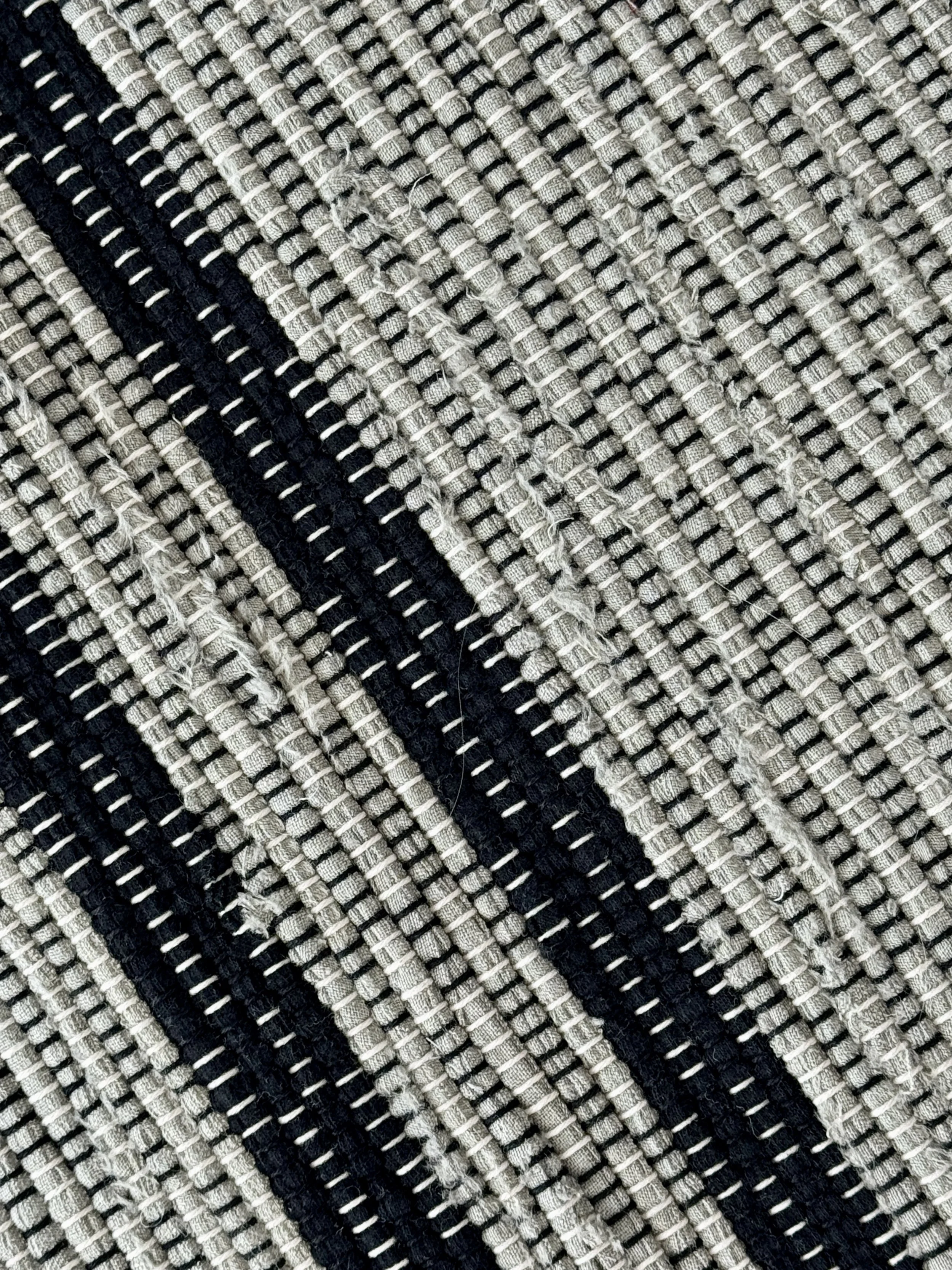 Close up handmade rag rug featuring texture and weave pattern