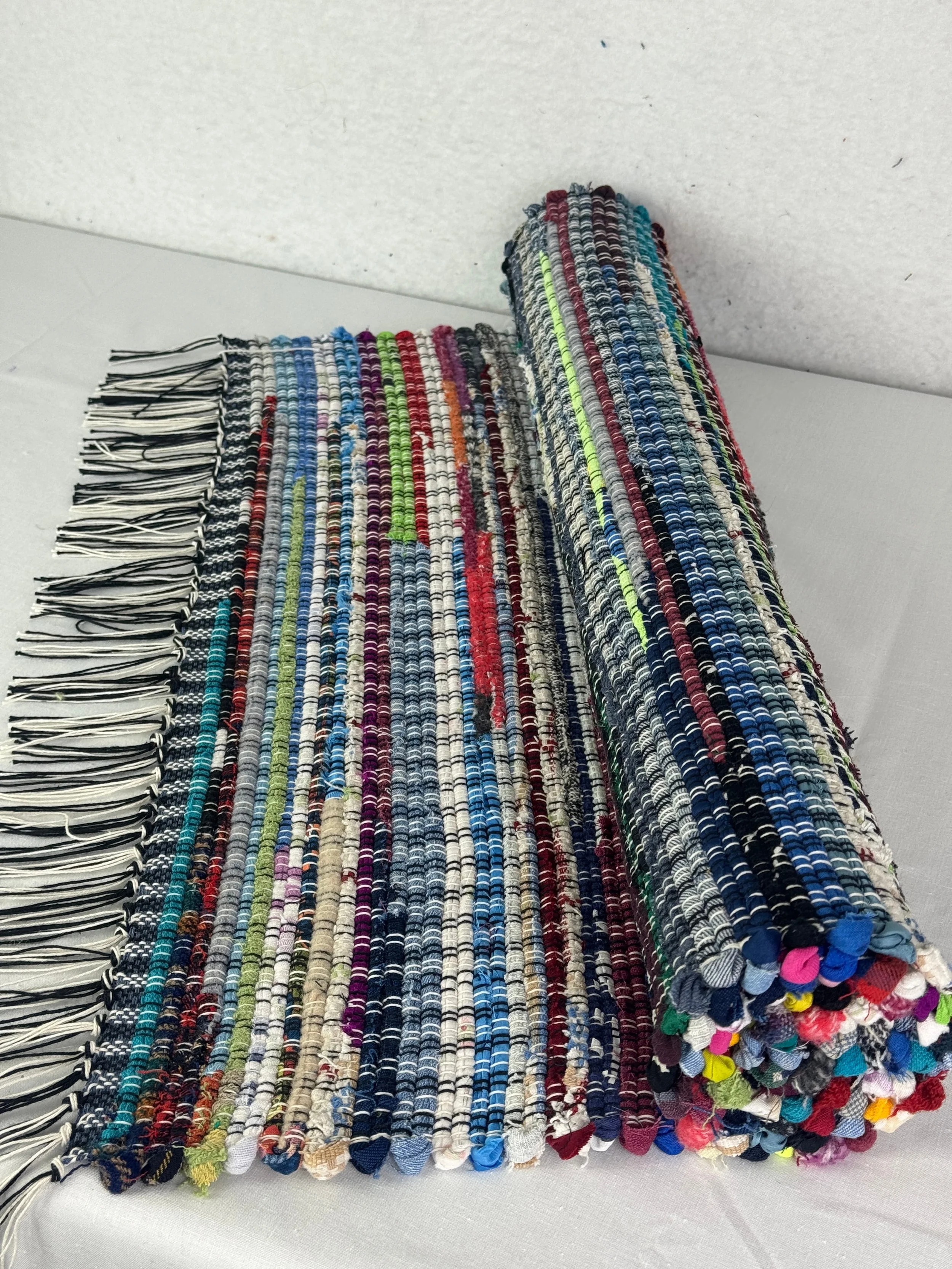 Handmade multi colored rag rug of various cotton and cotton blends 25" x 51"