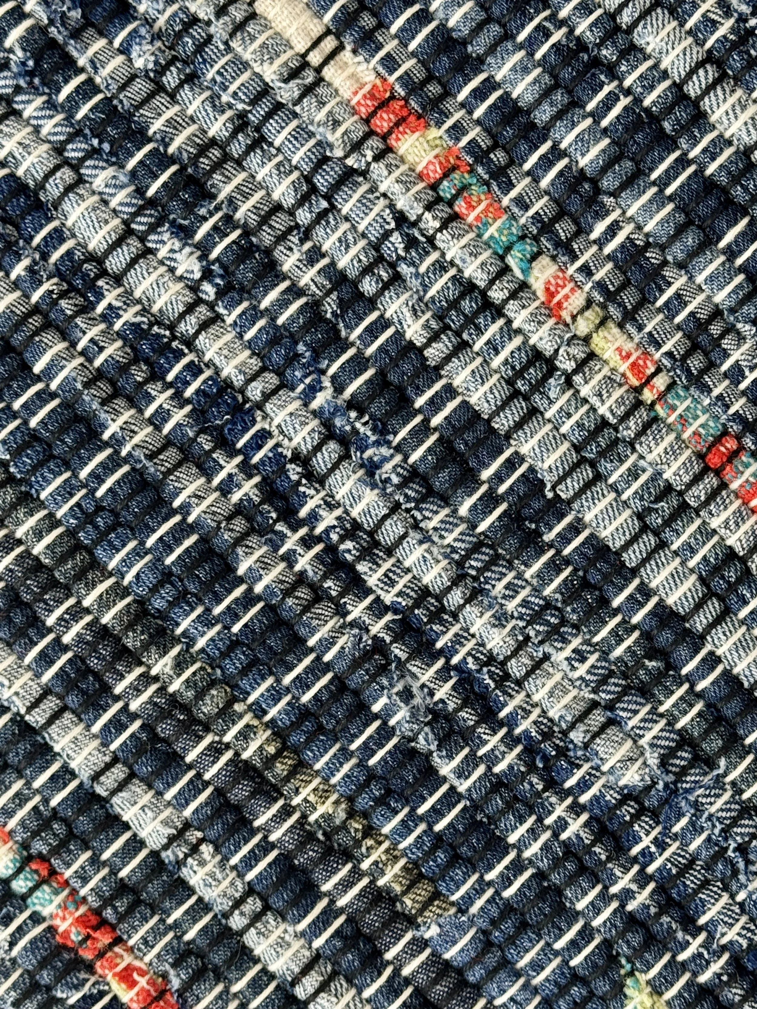 Close up handmade rag rug featuring texture and weave pattern of recycled denim