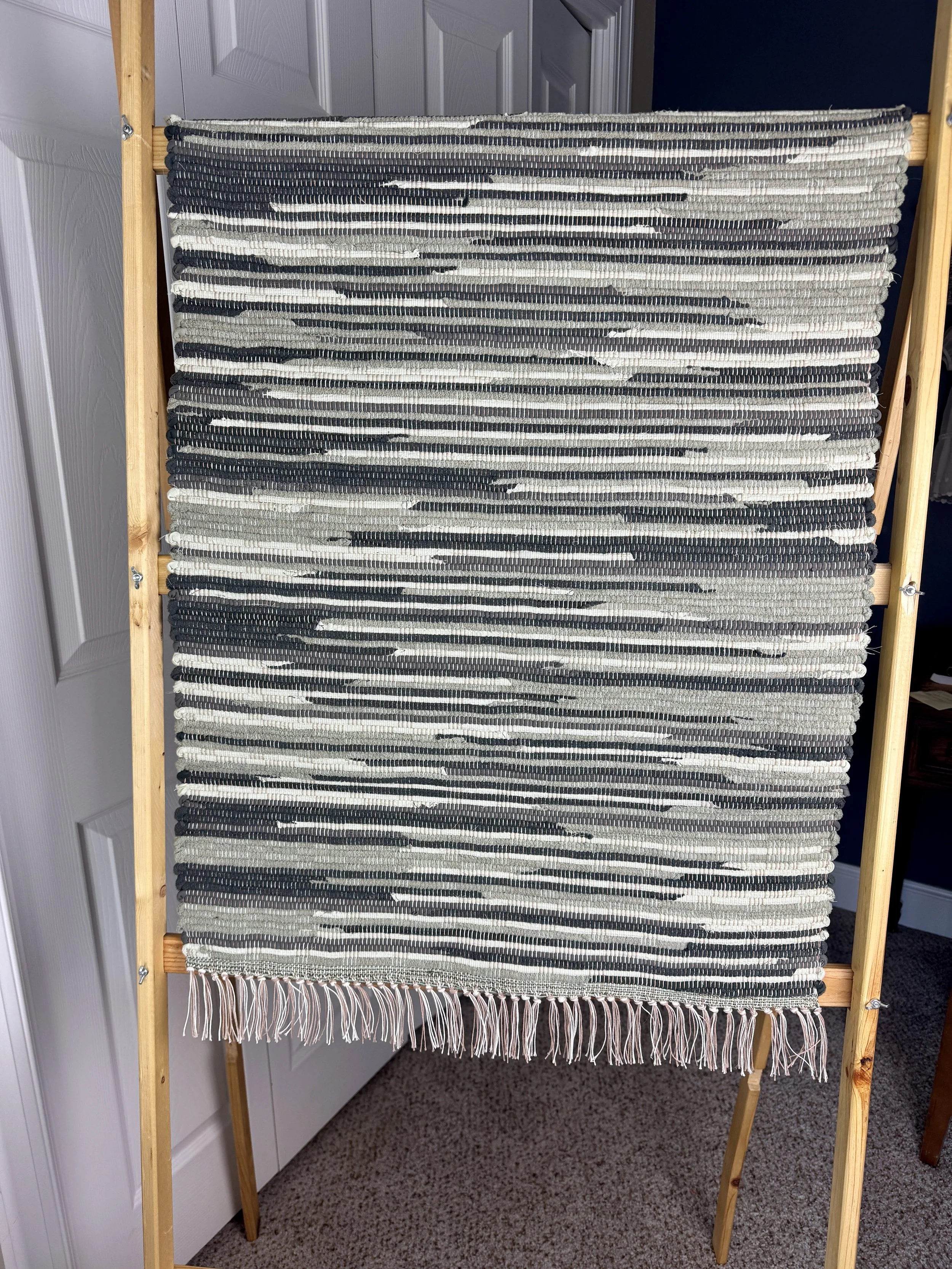 Hanging handmade upcycled textiles  rag rug showing pattern and fringe