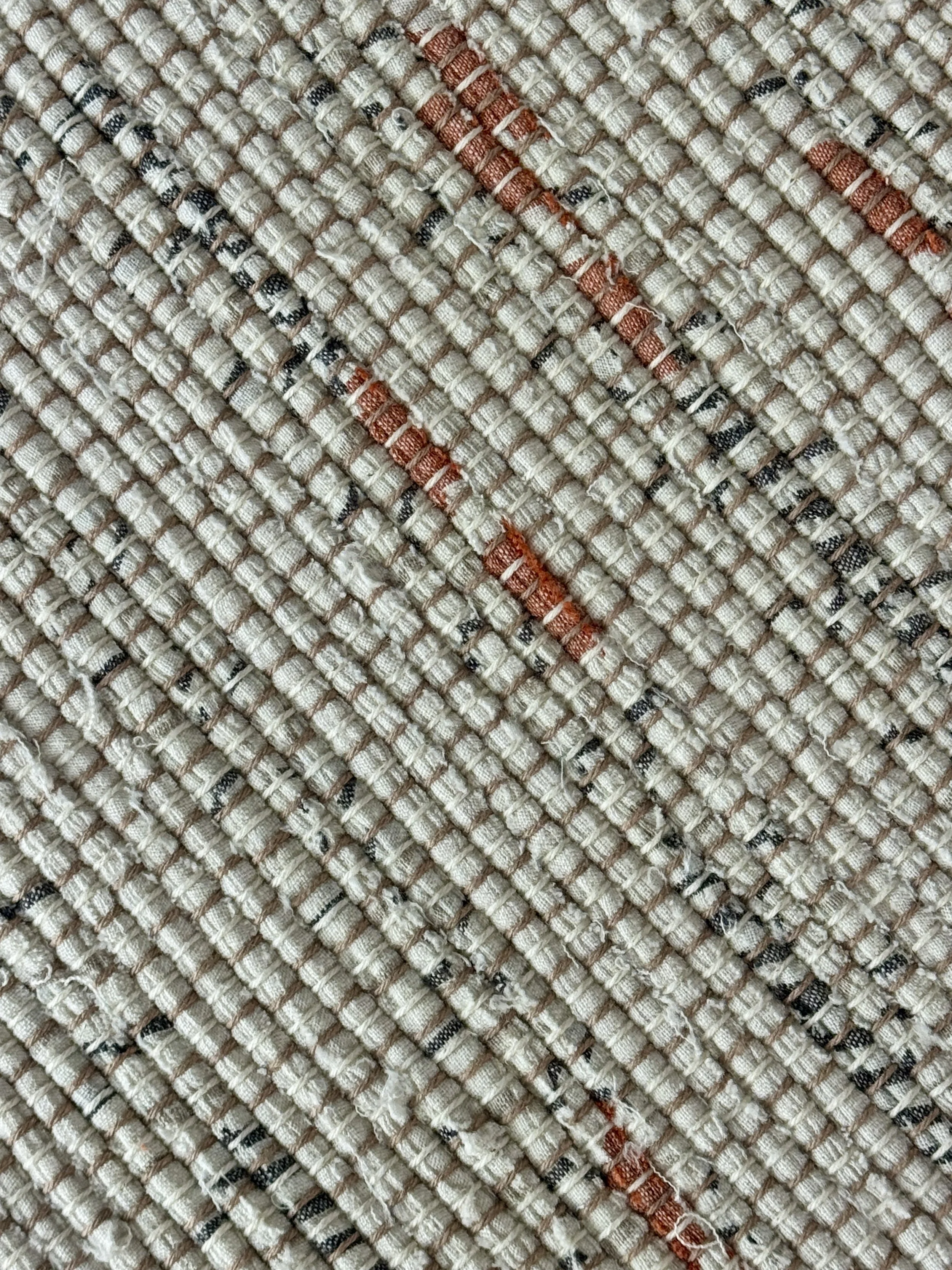 Up close handmade rag rug of upcycled cotton textiles showing texture and weave