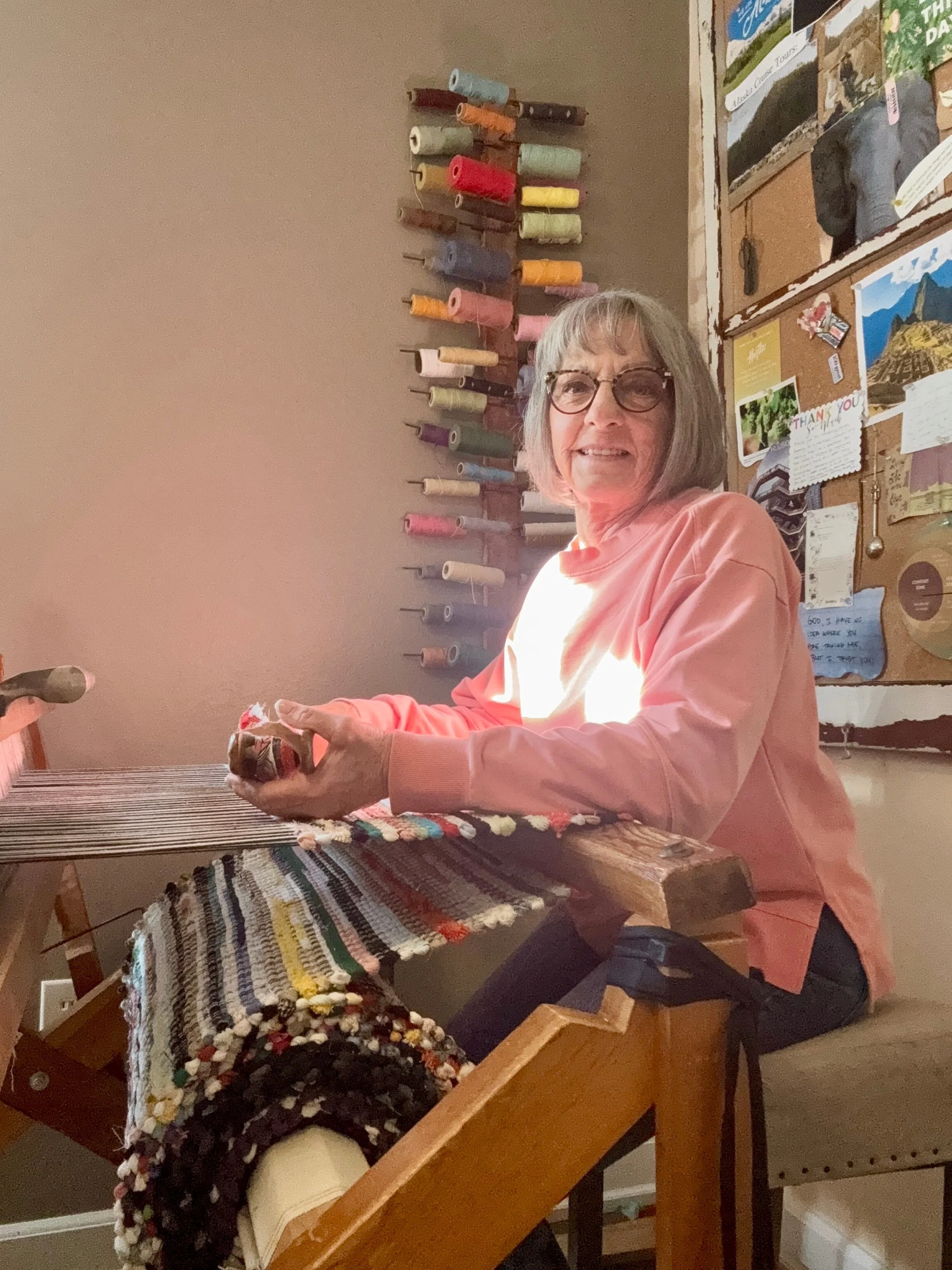 Terry weaving a handmade rag rug on wooden floor loom in her home