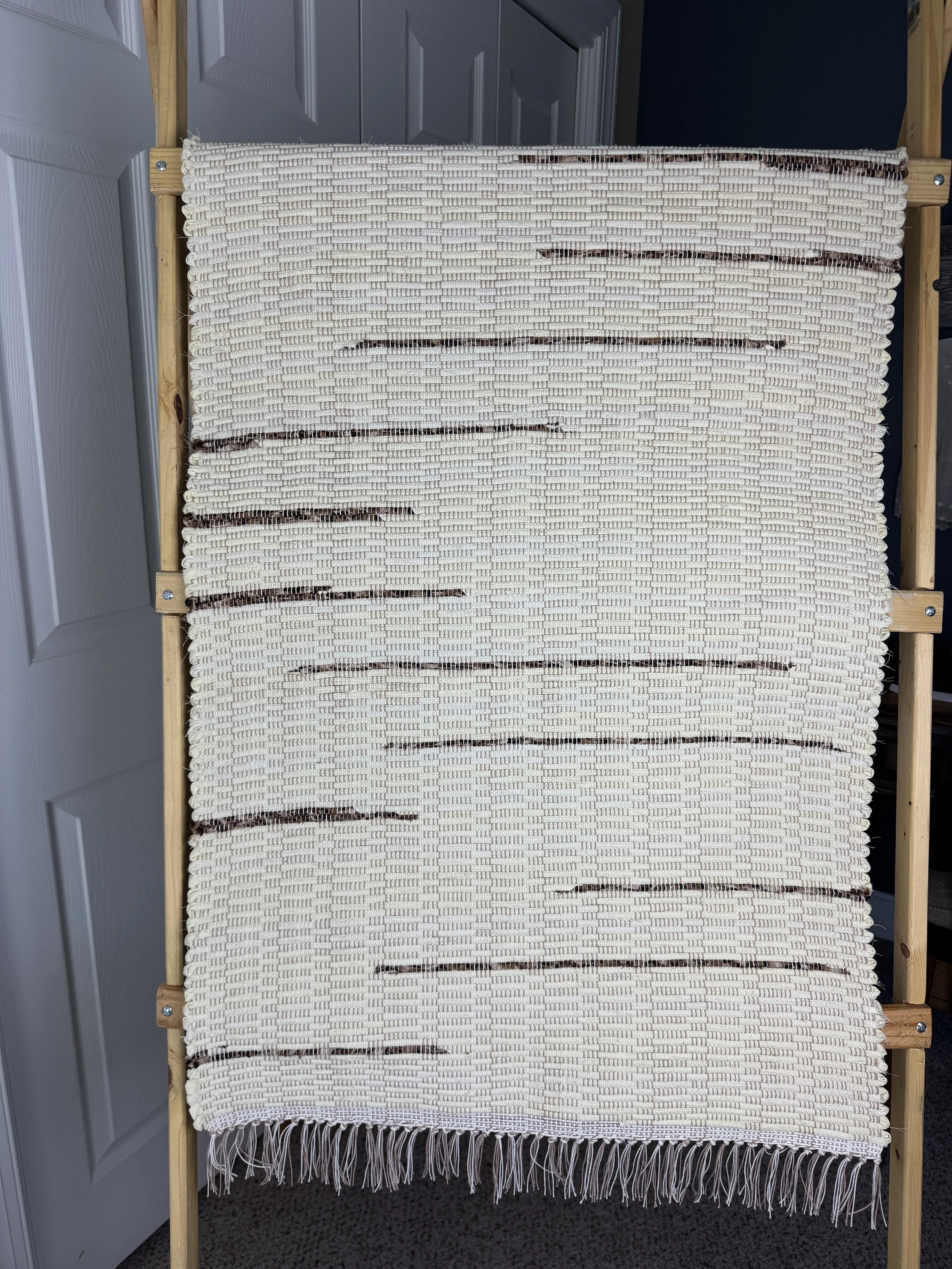 Handwoven hanging rag rug showing pattern and texture