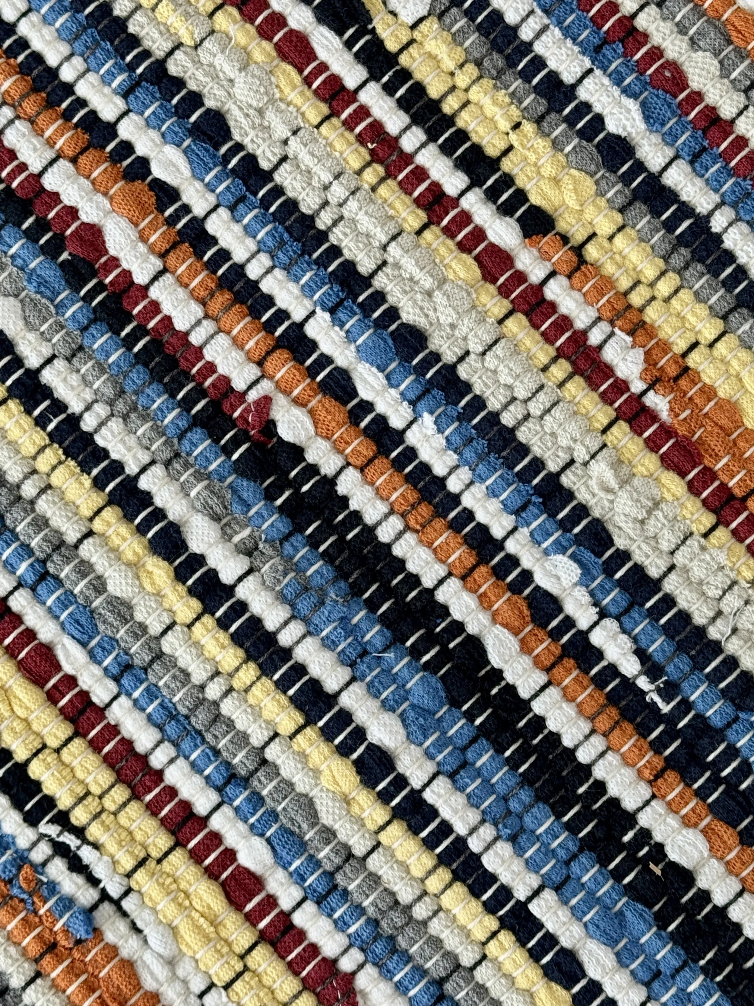 Close up handmade rag rug featuring texture and weave pattern