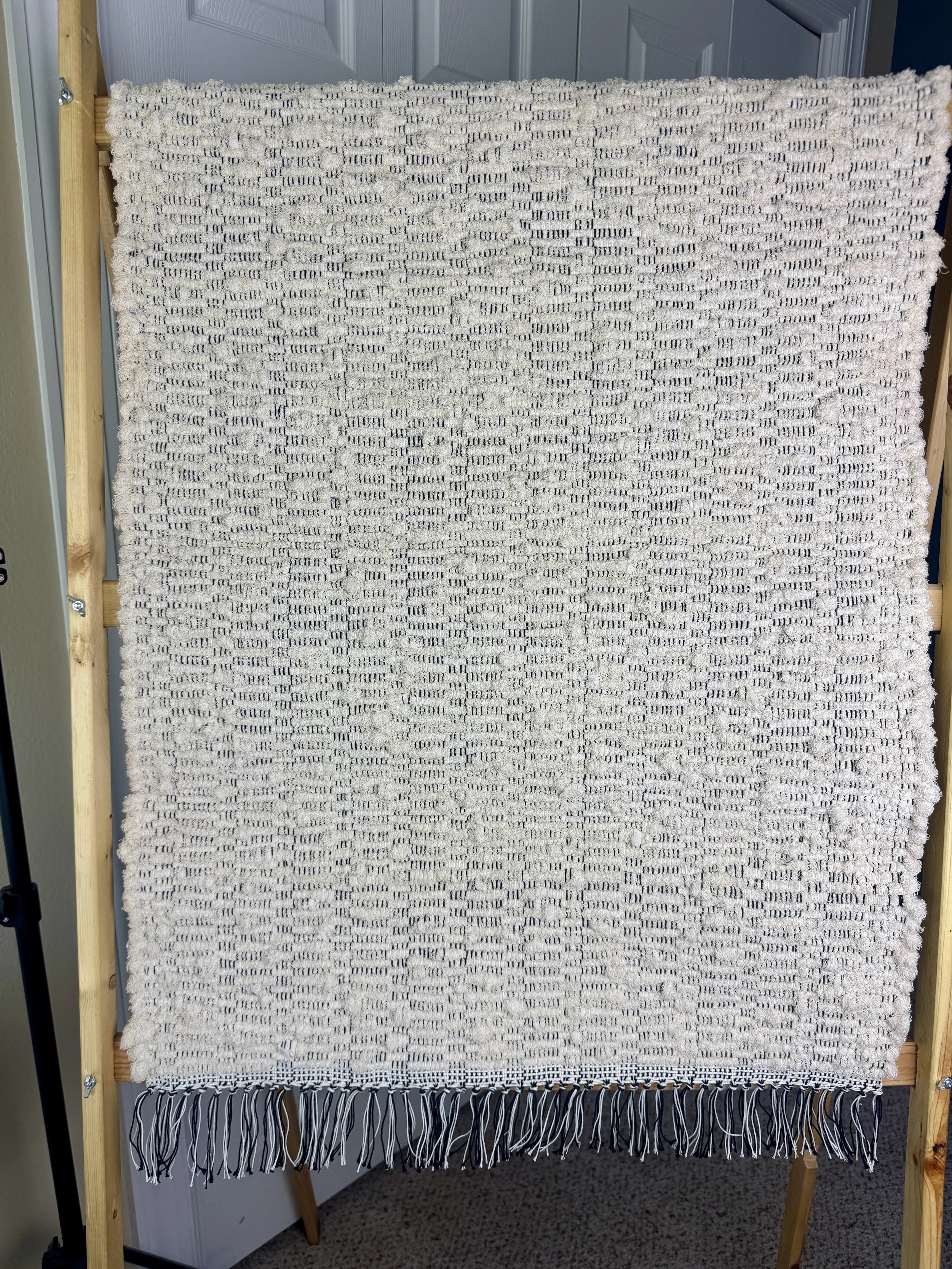 Hanging handmade recycled sock loopers  rag rug showing pattern and fringe