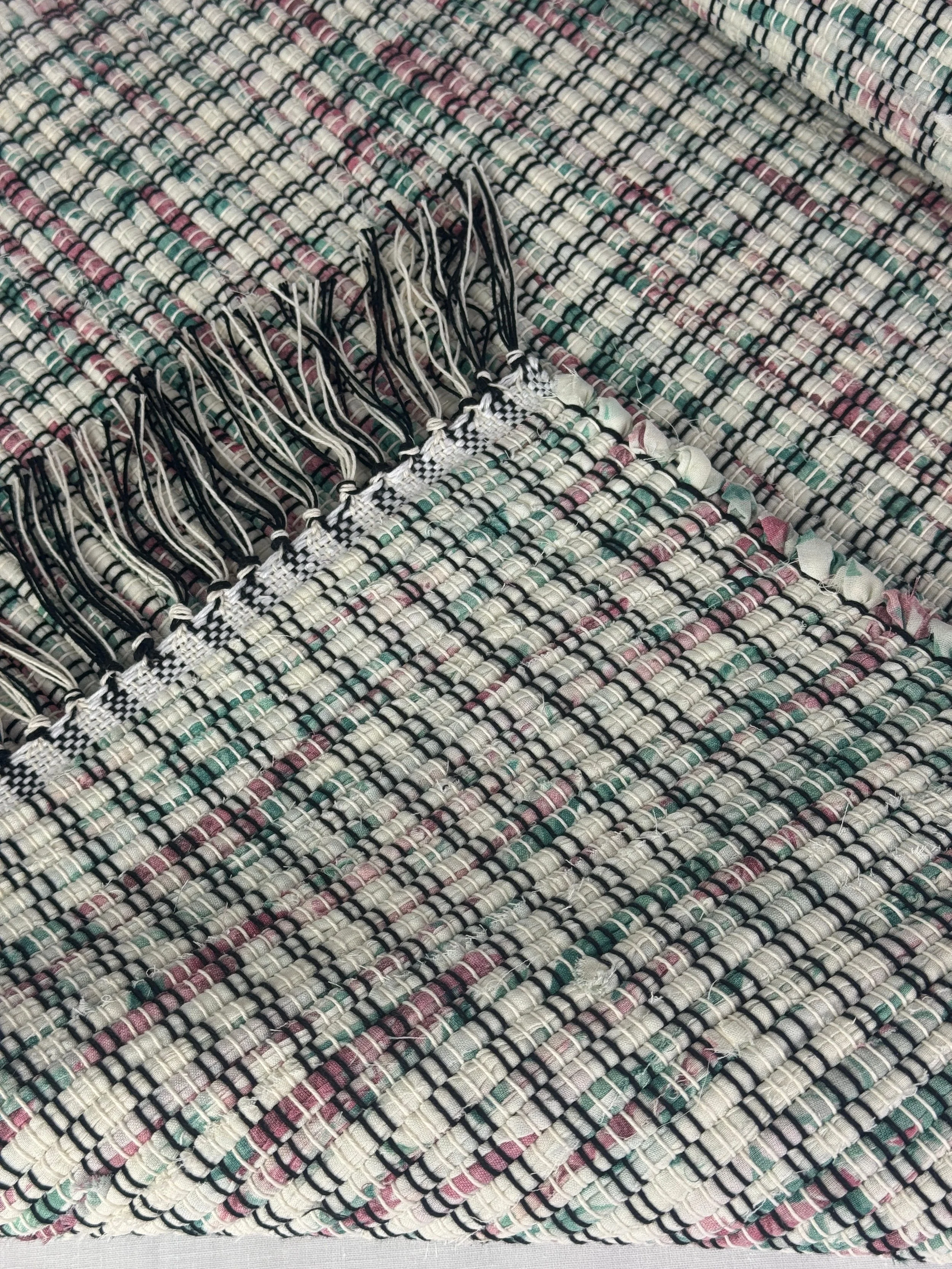 Pastel Handwoven rag rug fold to show reverse side and fringe