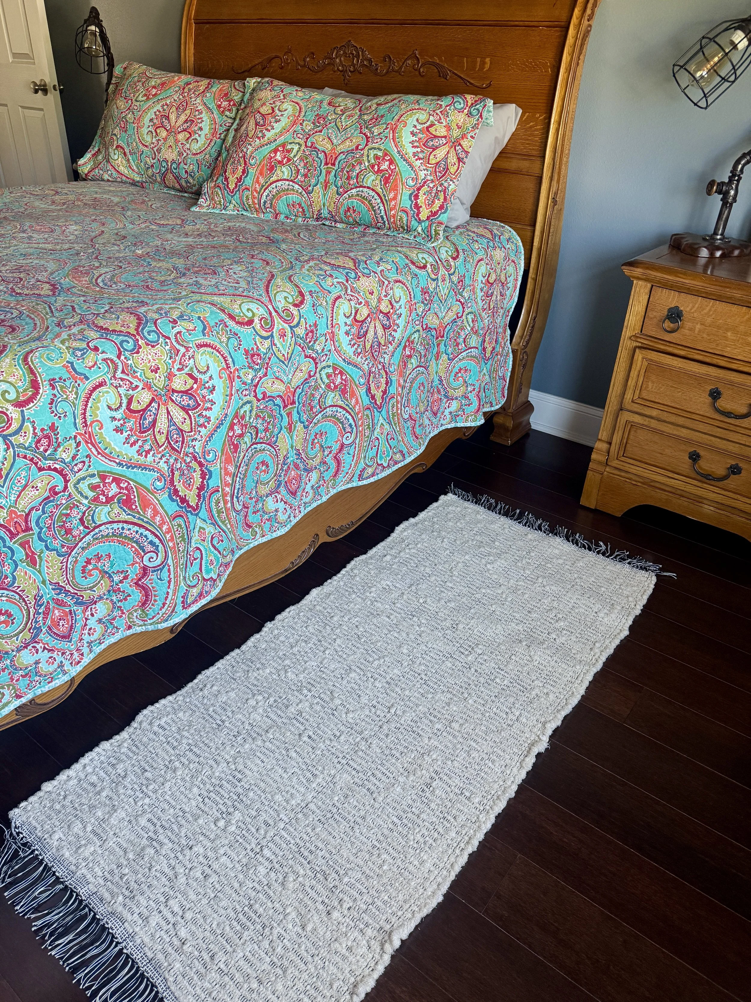 Displayed handcrafted rag rug in bedroom showing pattern