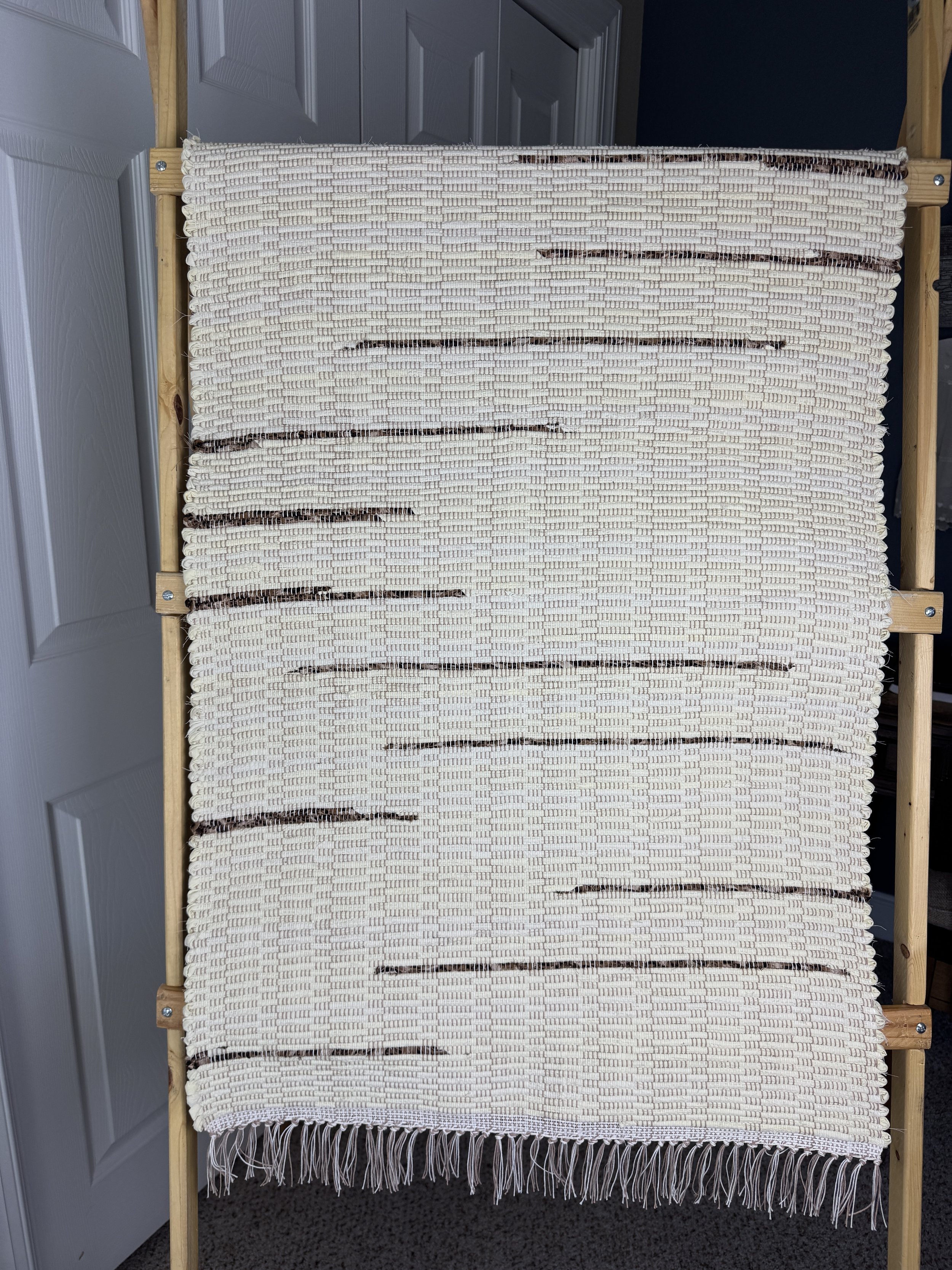 Handwoven rag rug hanging showing weave and pattern