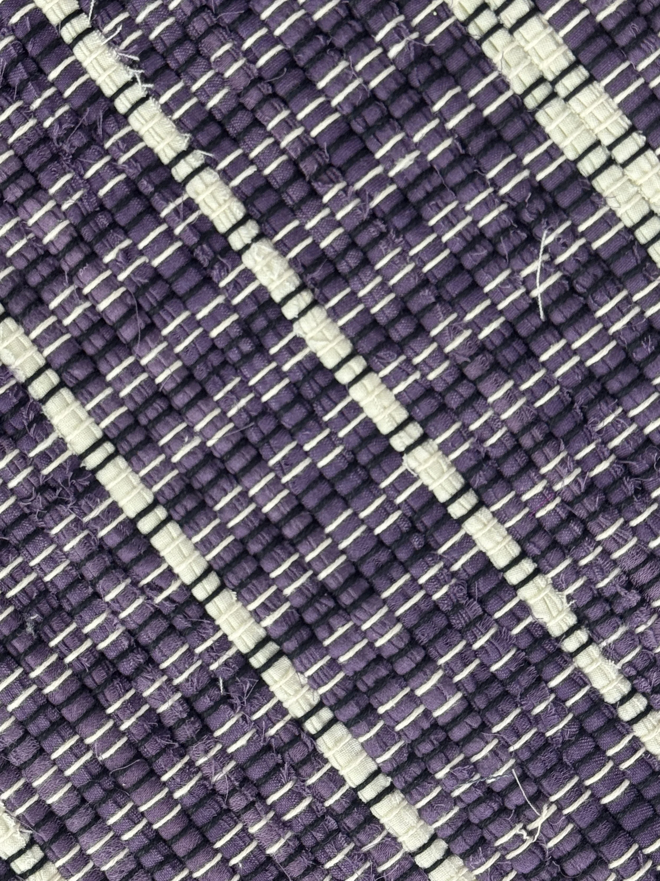 Purple/white handwoven rag rug close-up showing texture
