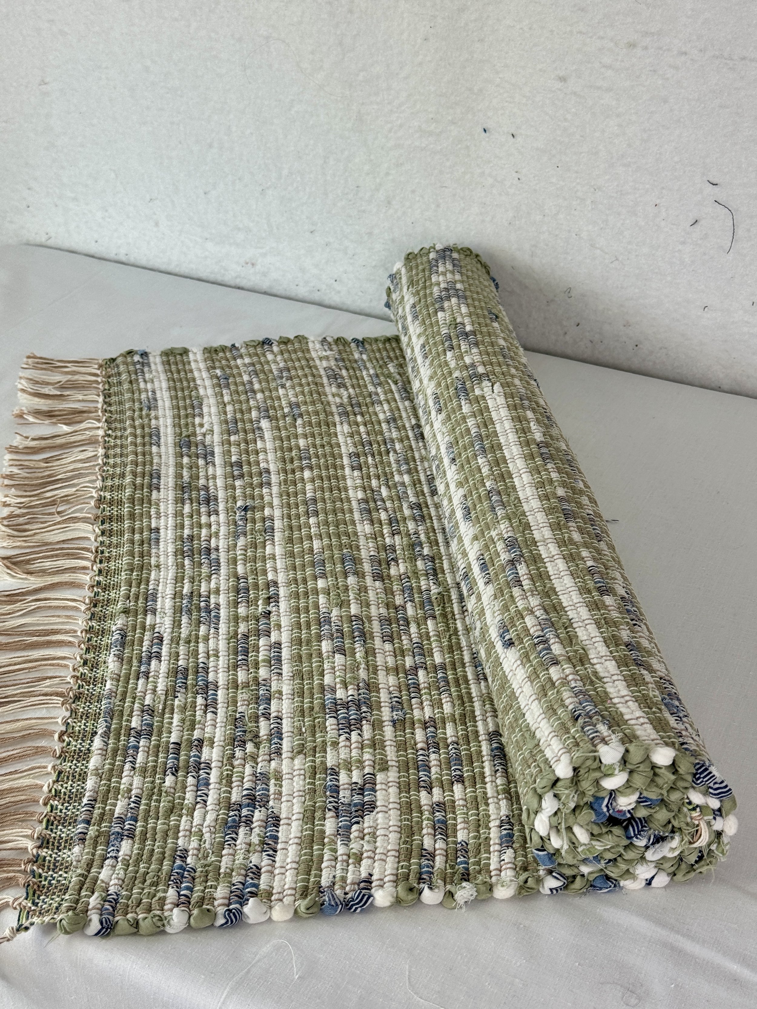 Handwoven green, navy, white rag rug woven with recycled textiles