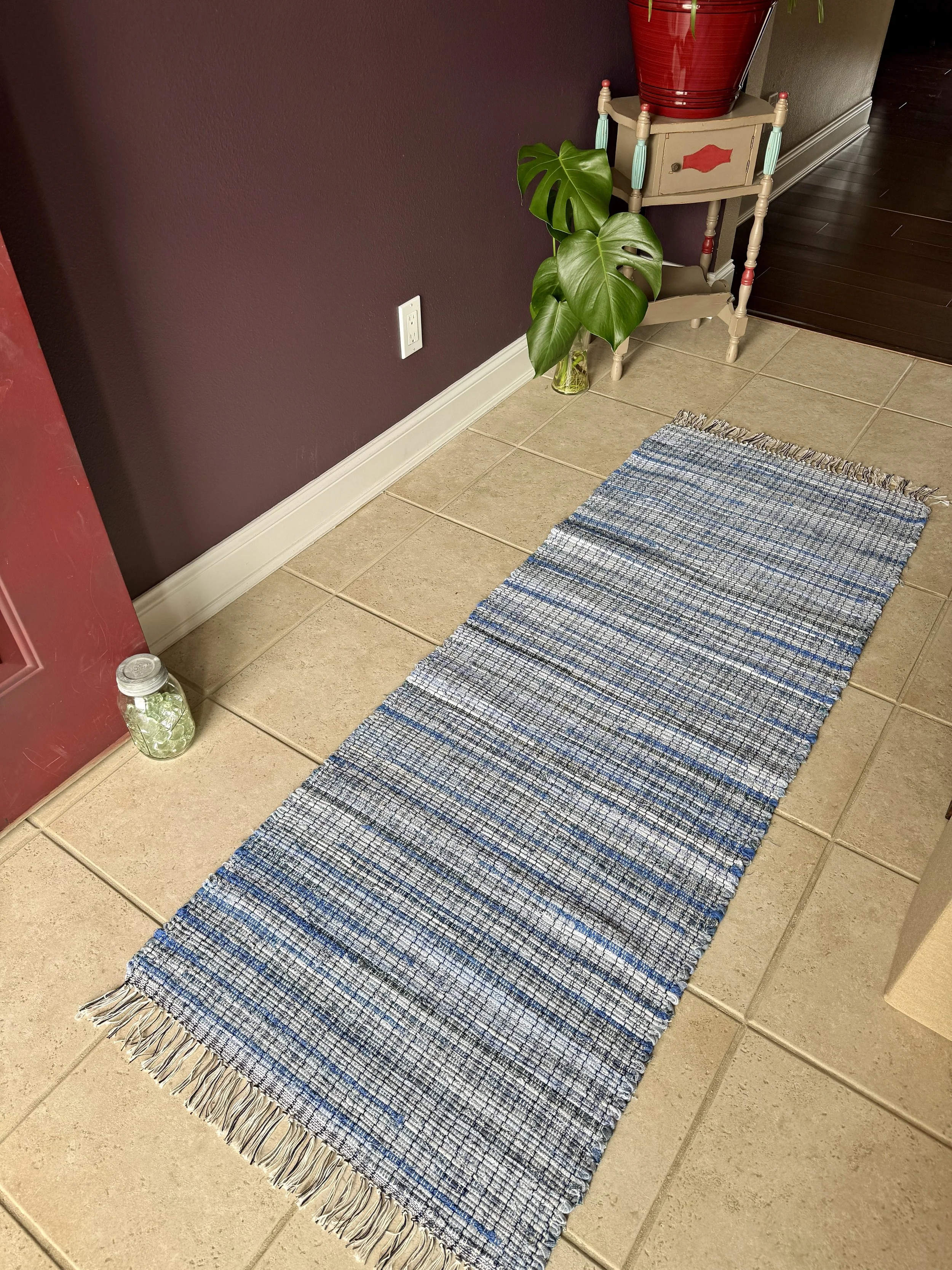 Displayed handcrafted rag rug in entryway showing pattern