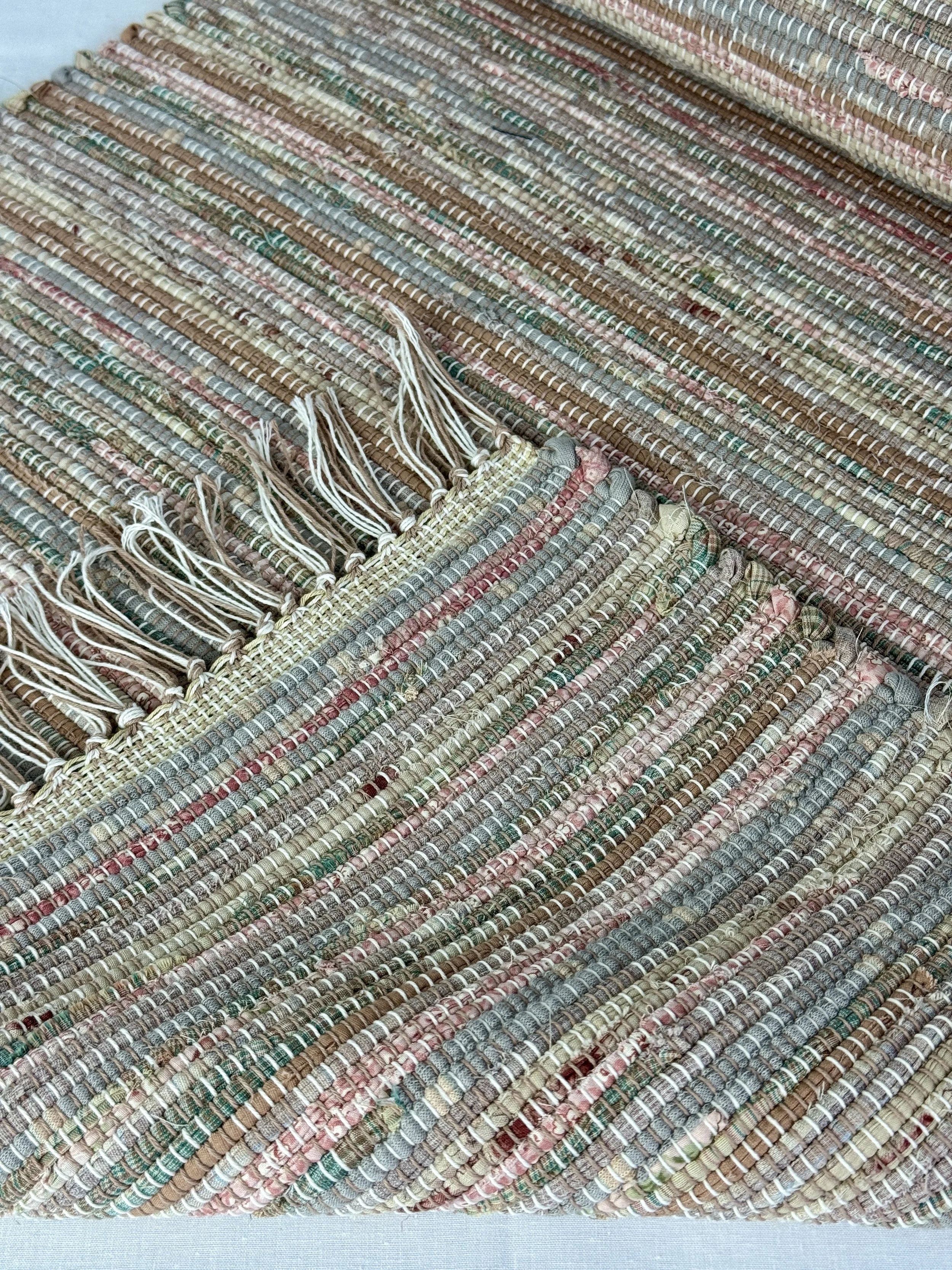 Close up handmade rag rug featuring texture and fringe