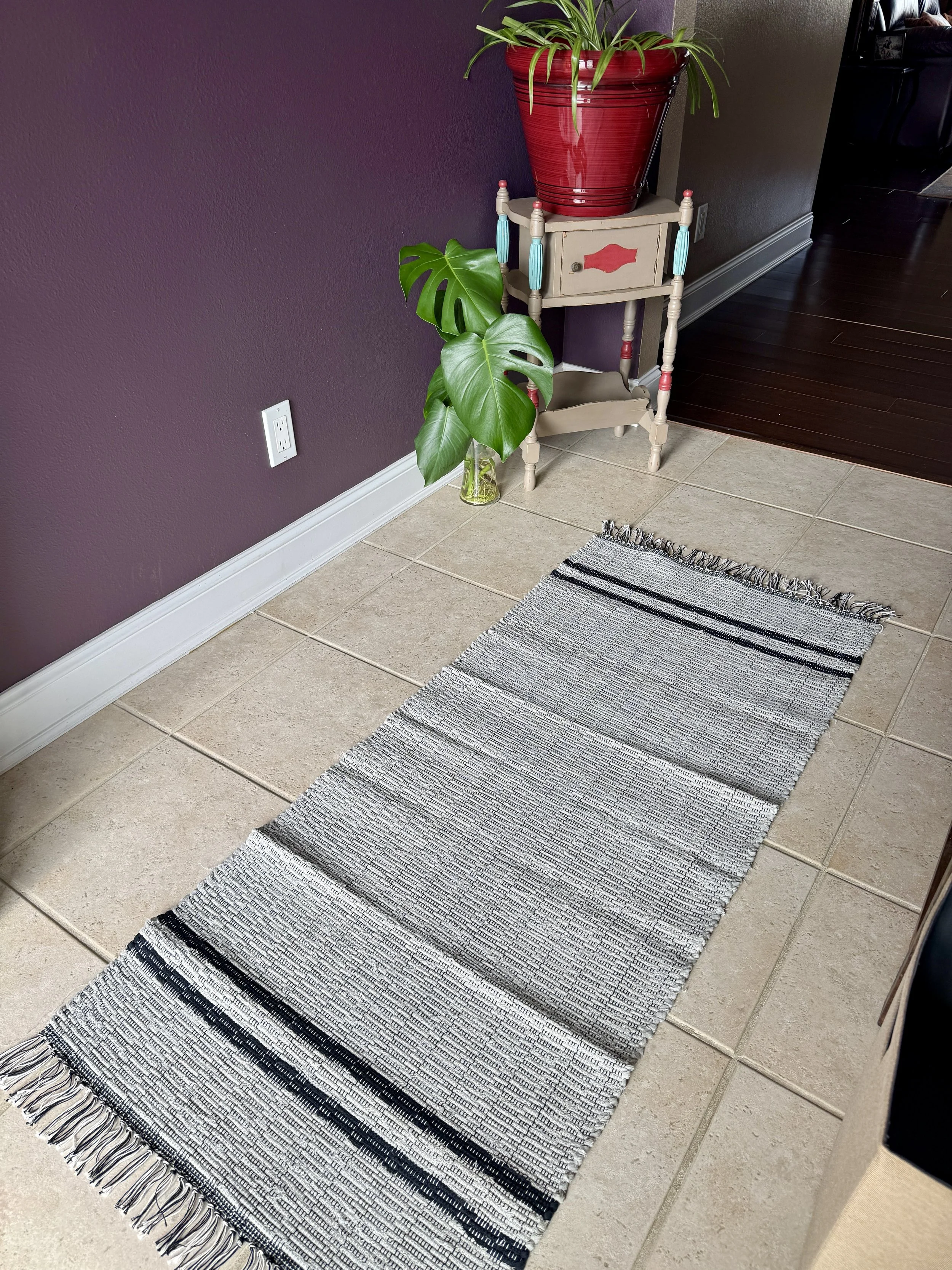 Displayed handcrafted rag rug in entry way showing pattern