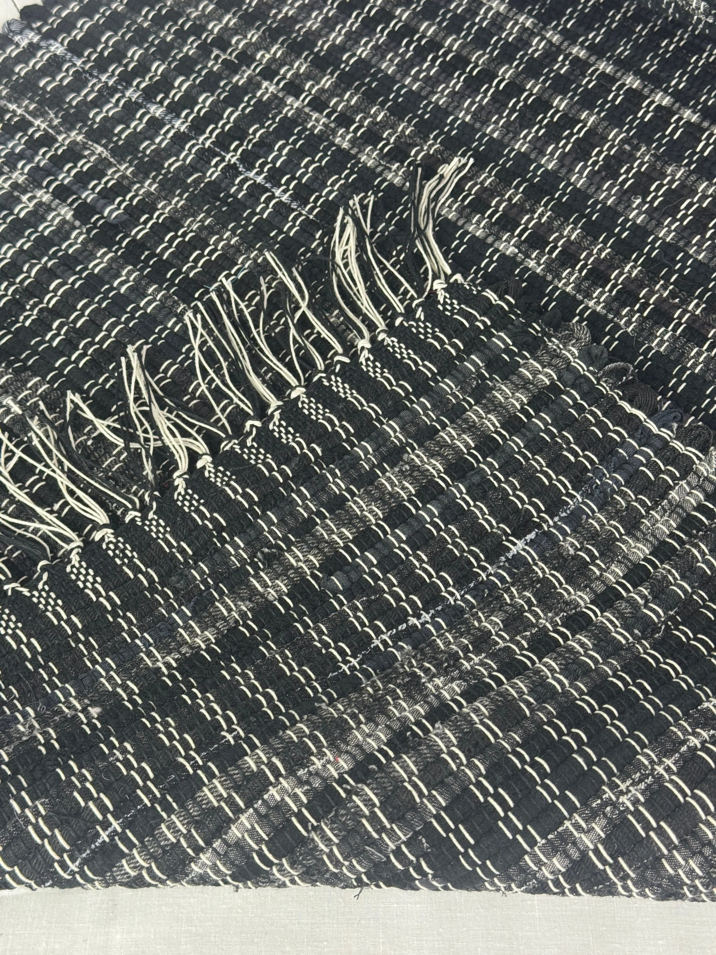 Close-up texture of black handwoven rag rug recycled cotton blendloom woven rug