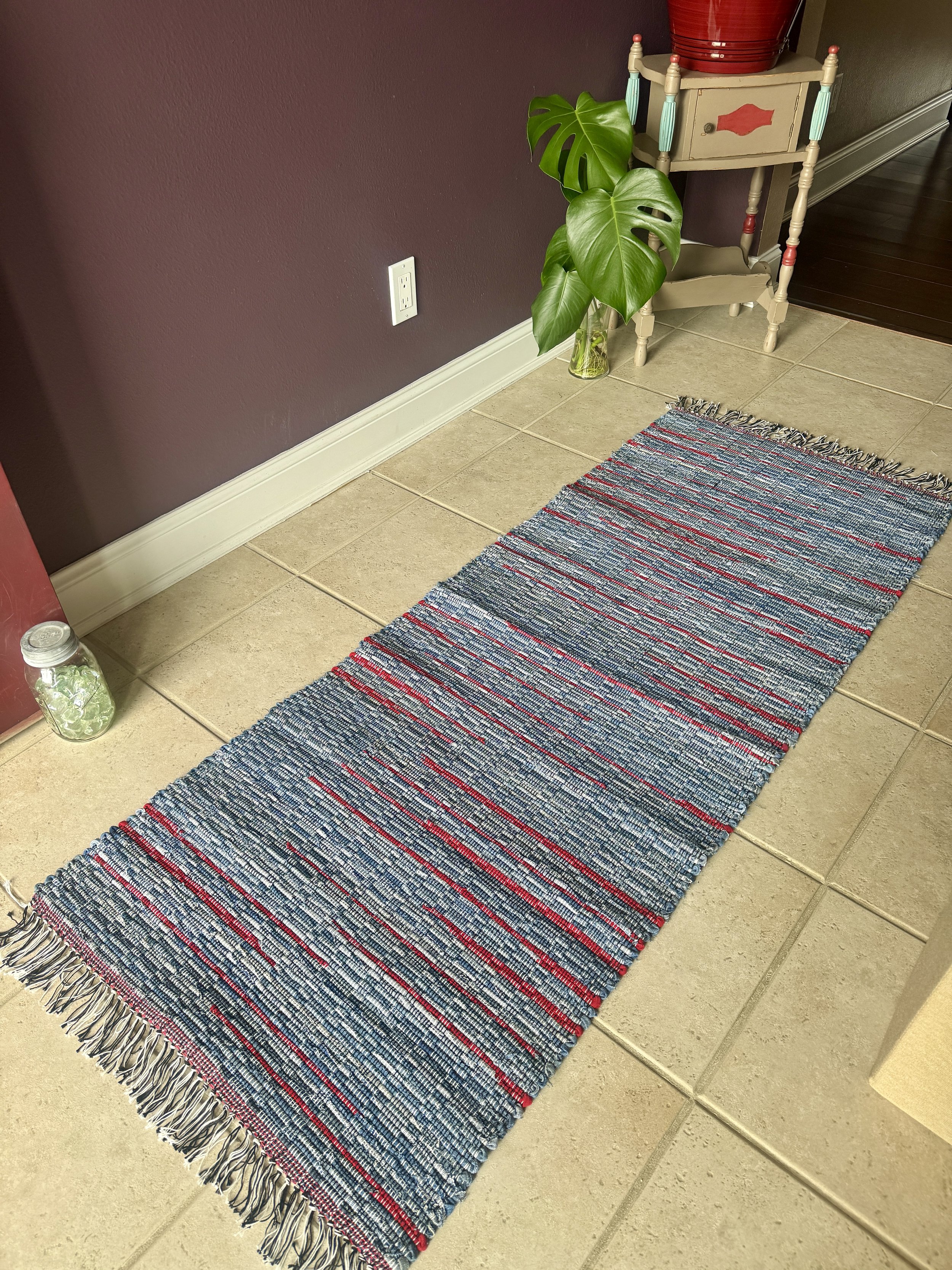 Displayed handcrafted rag rug in entryway showing pattern