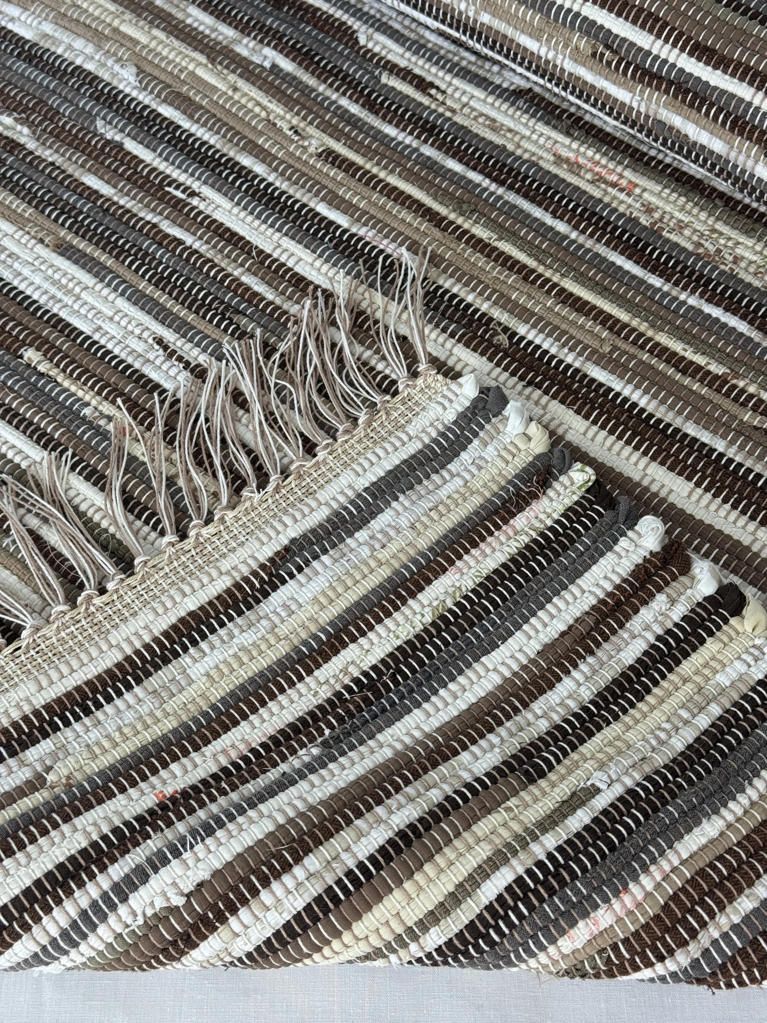 Handwoven rag rug folded showing reverse side and fringe