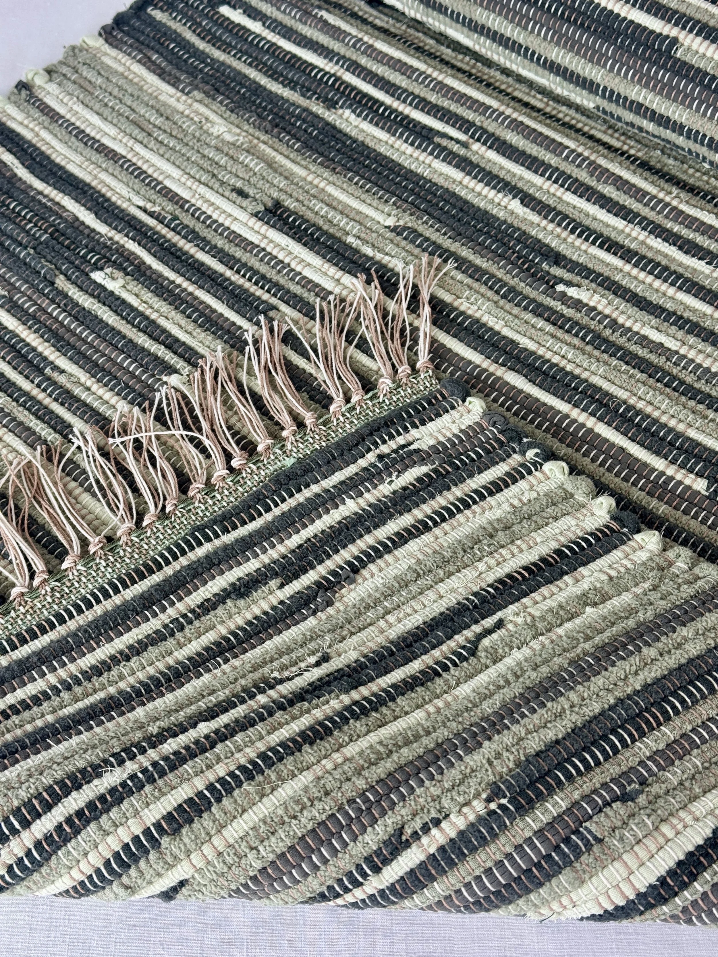 Close up handmade rag rug featuring texture and weave pattern