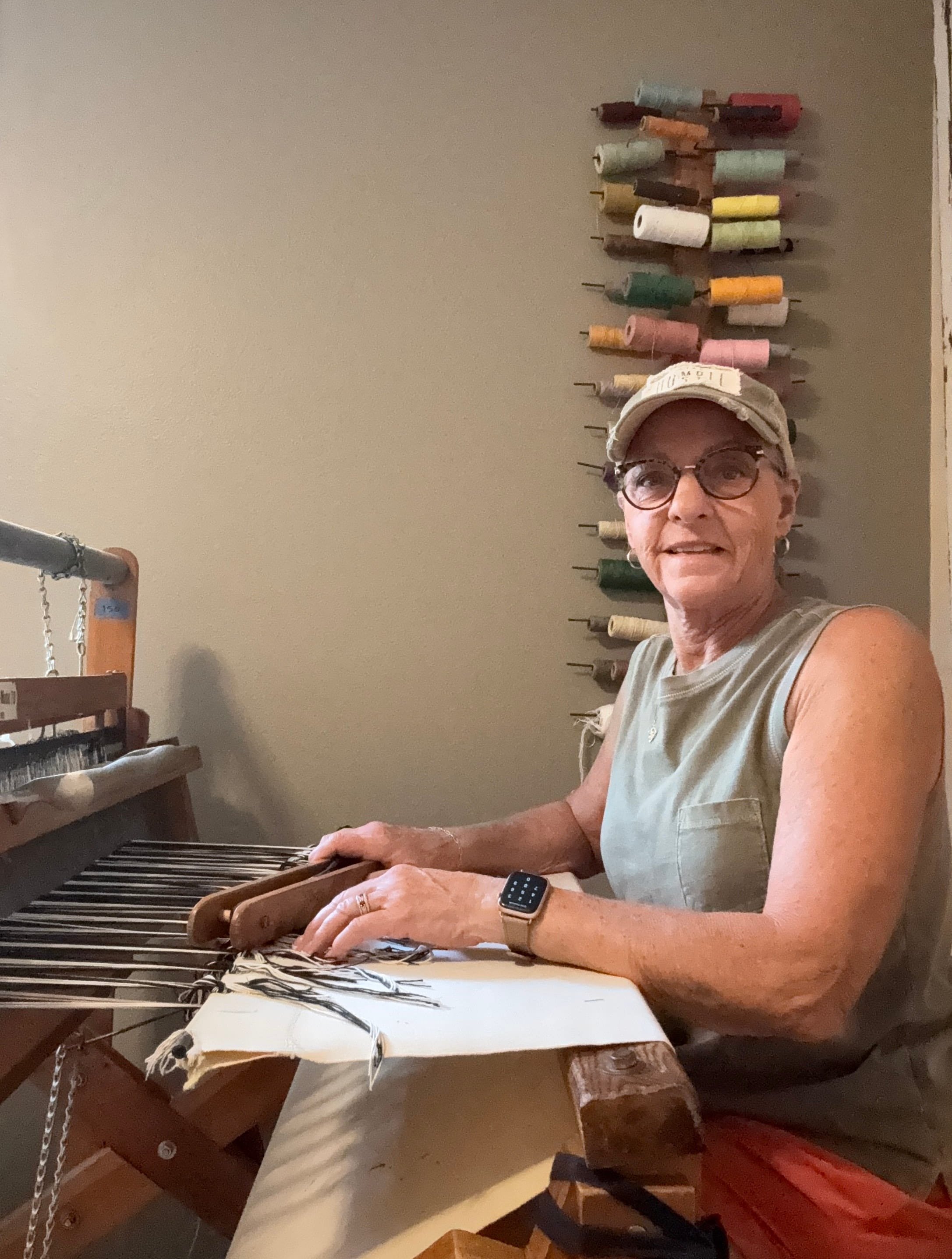Terry weaving a handmade rag rug on wooden floor loom in her home