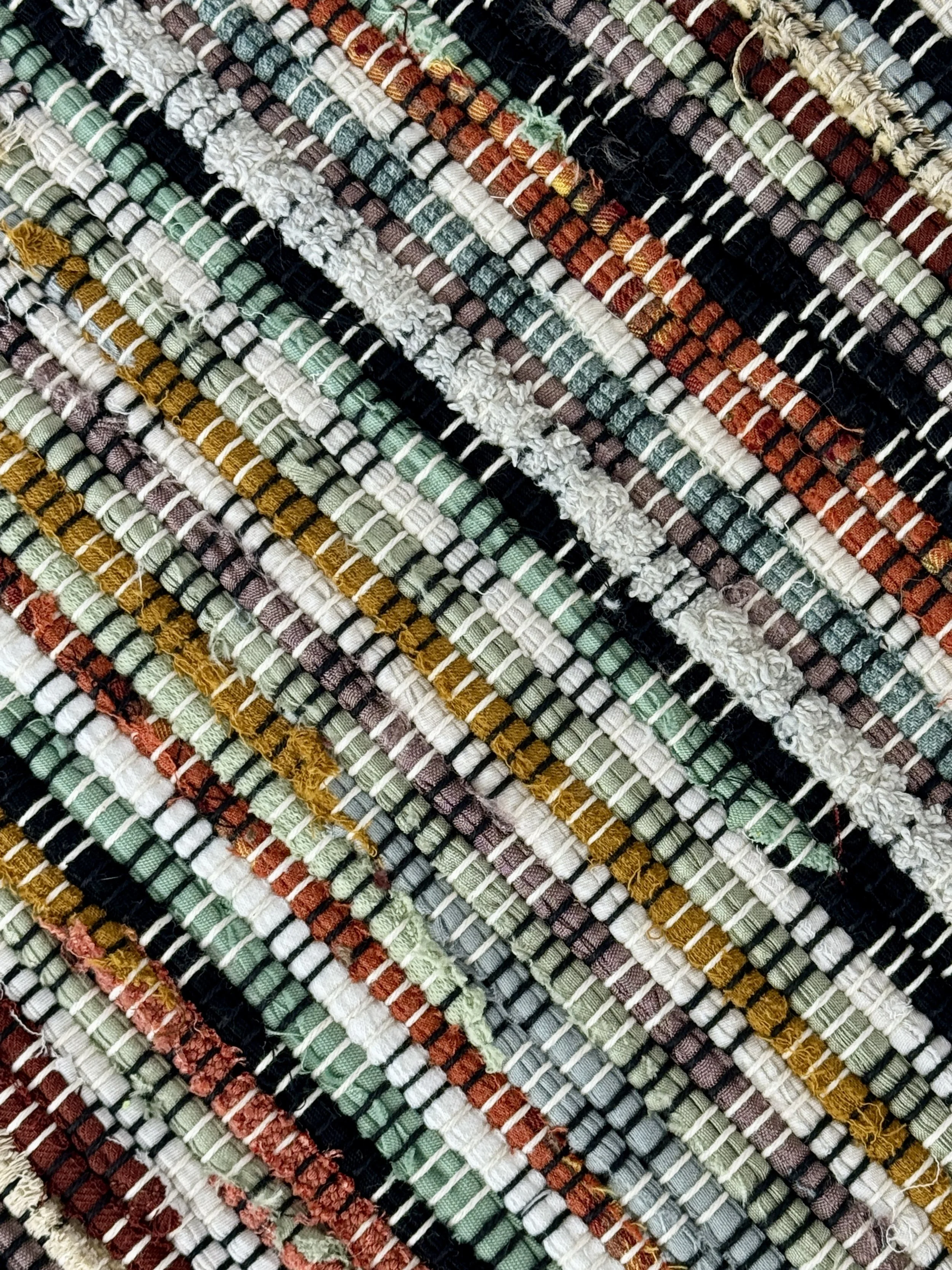 Folded handmade rug showing reverse side and fringe