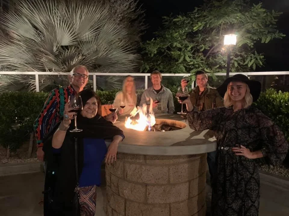 Guests gather around the fire pit to relax, share conversation, and enjoy the evening beneath the Palm Springs sky.