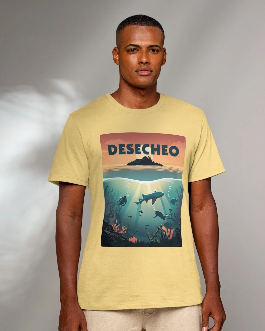 Model wears yellow tshirt with scuba diving artwork of a dive site in Desecheo island Puerto Rico