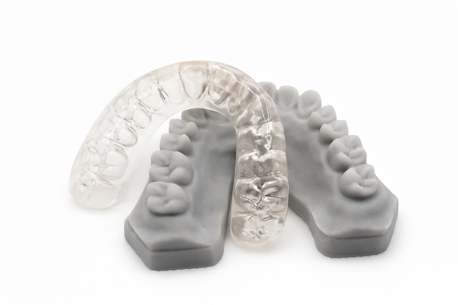 Two dental models, one transparent and one opaque, showing upper and lower teeth.