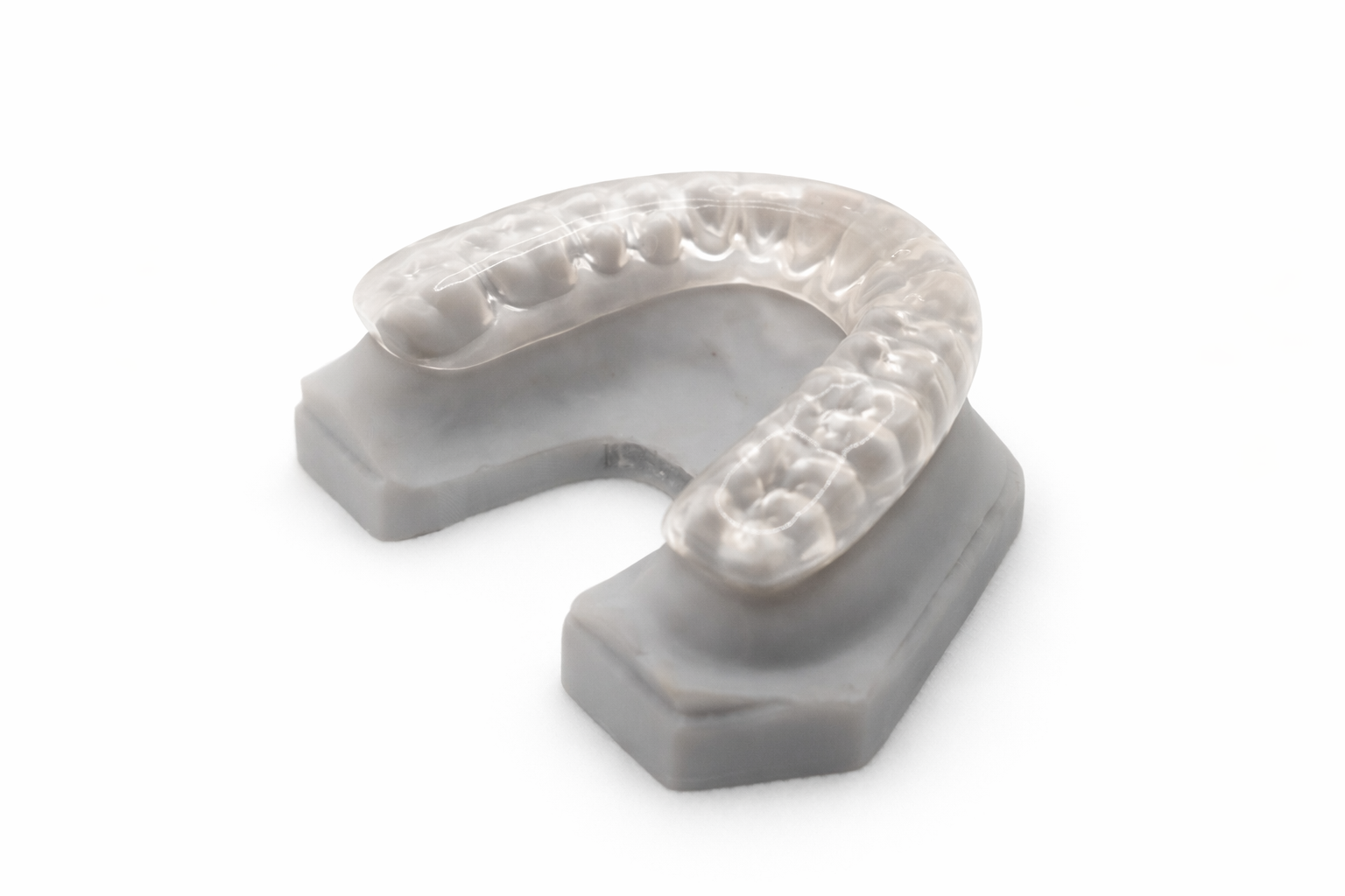 A dental impression mold with a transparent tray and a gray base, used for creating dental prosthetics.