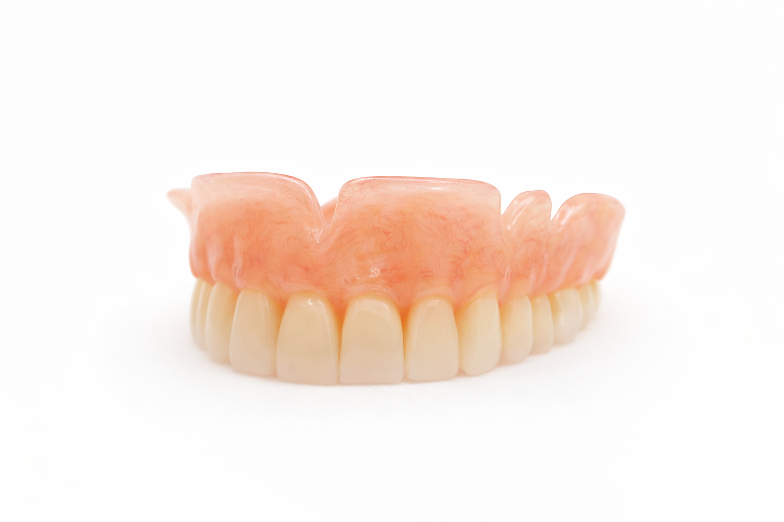 A set of artificial lower dentures with pink gum-colored base and ivory teeth on a white background.