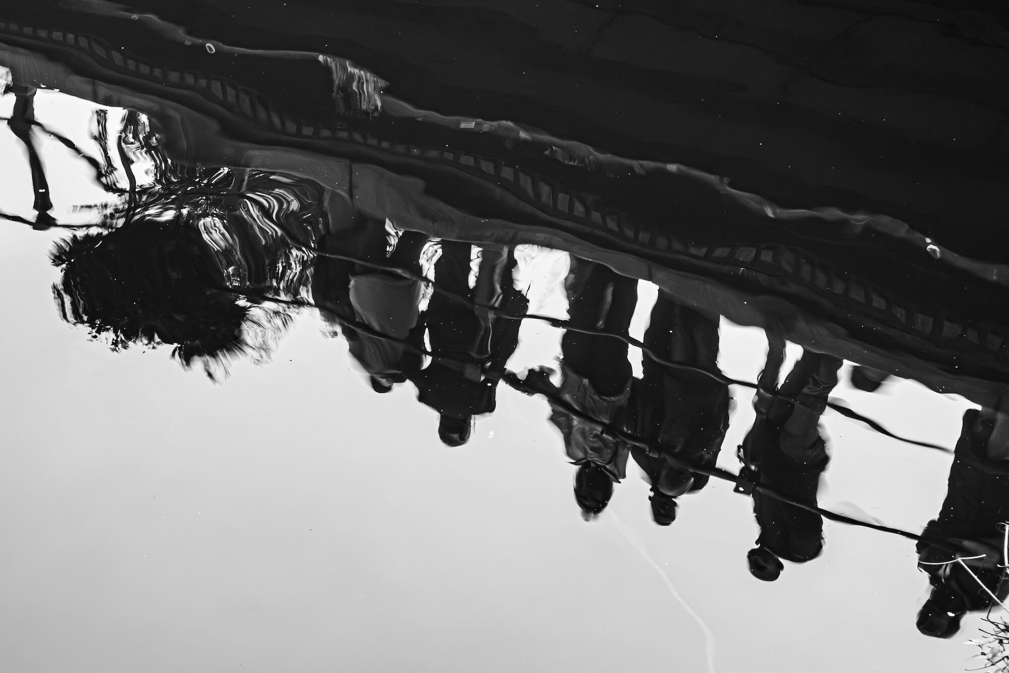 Reflections of people looking at a canal in Amsterdam