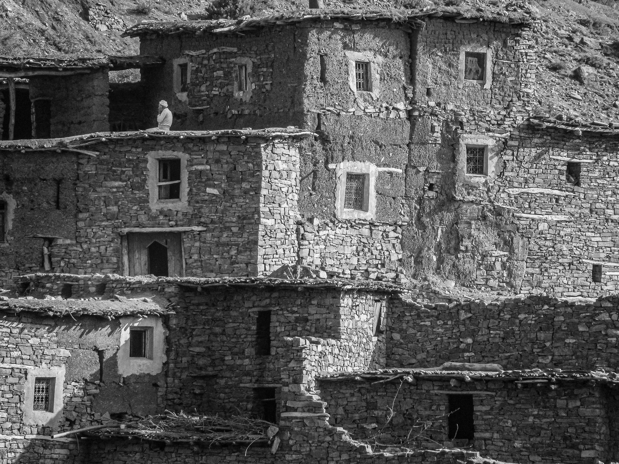 Berber man praying on his rooftop in a village in the Atlas Mountains Morocco