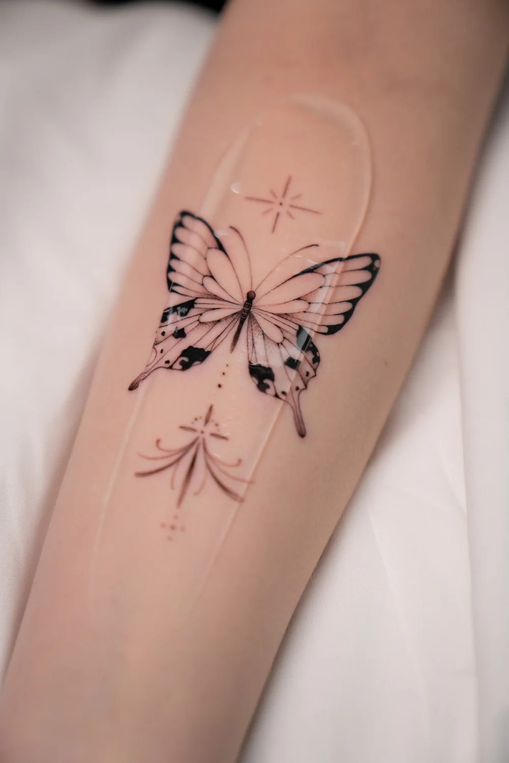 Mariposa fine line en el antebrazo