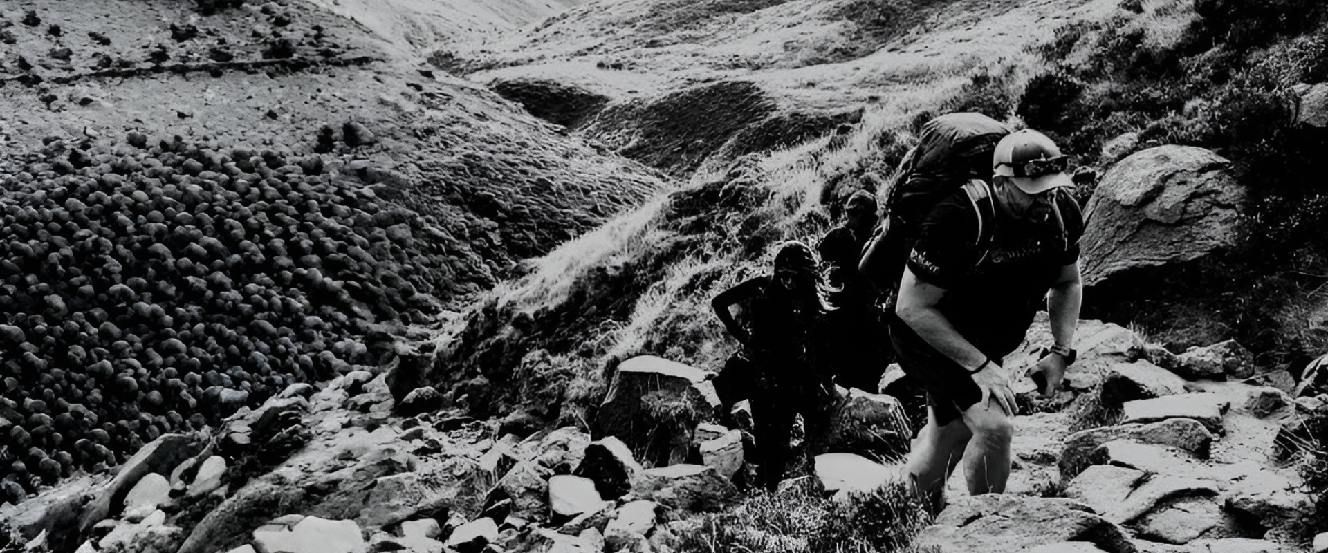 Group of hikers climbing rocky terrain in a mountainous area