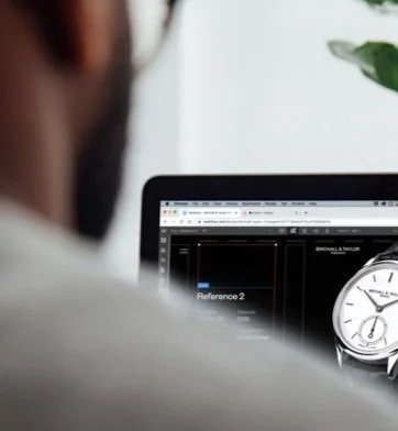 Person looking at a computer screen displaying a watch design and a clock.