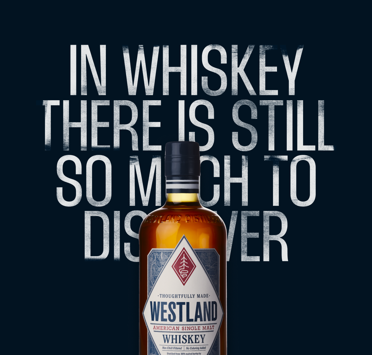 A bottle of Westland American Single Malt Whiskey in front of a dark background with the quote 'In whiskey there is still so much to discover' written in large, distressed text.