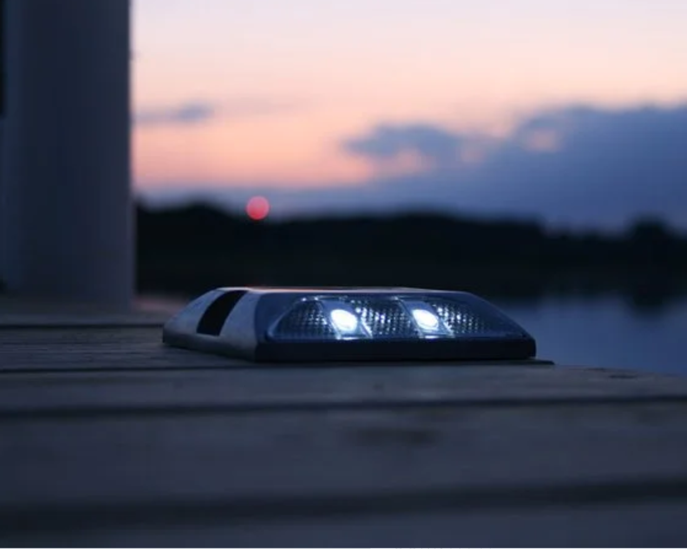 Low-profile solar deck light installed on dock surface providing subtle nighttime pathway illumination by K+R Manufacturing