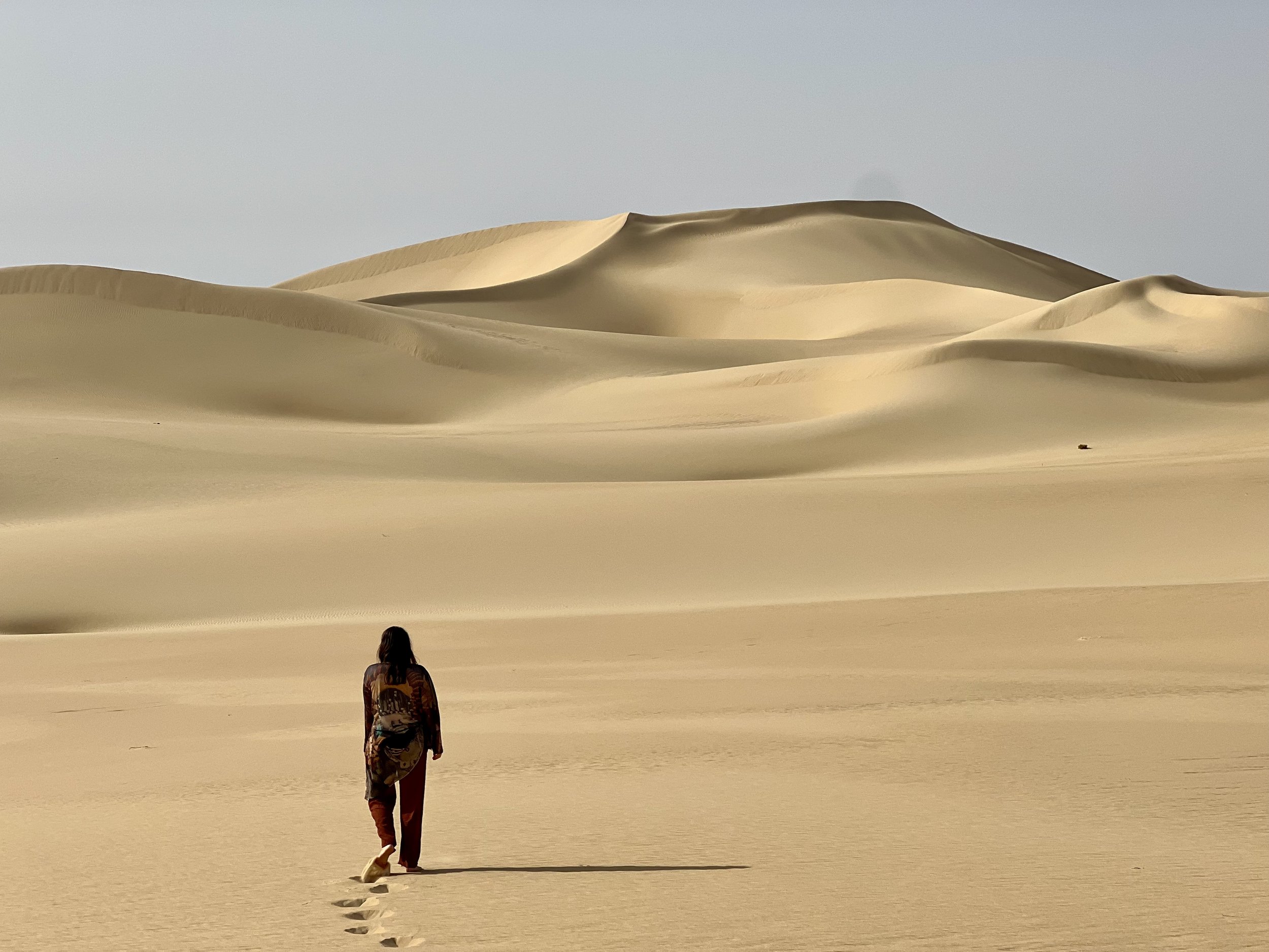 mulher caminha pelas dunas do Great Sea of Sand no deserto do Saara egípcio em viagem com Arca Jornadas
