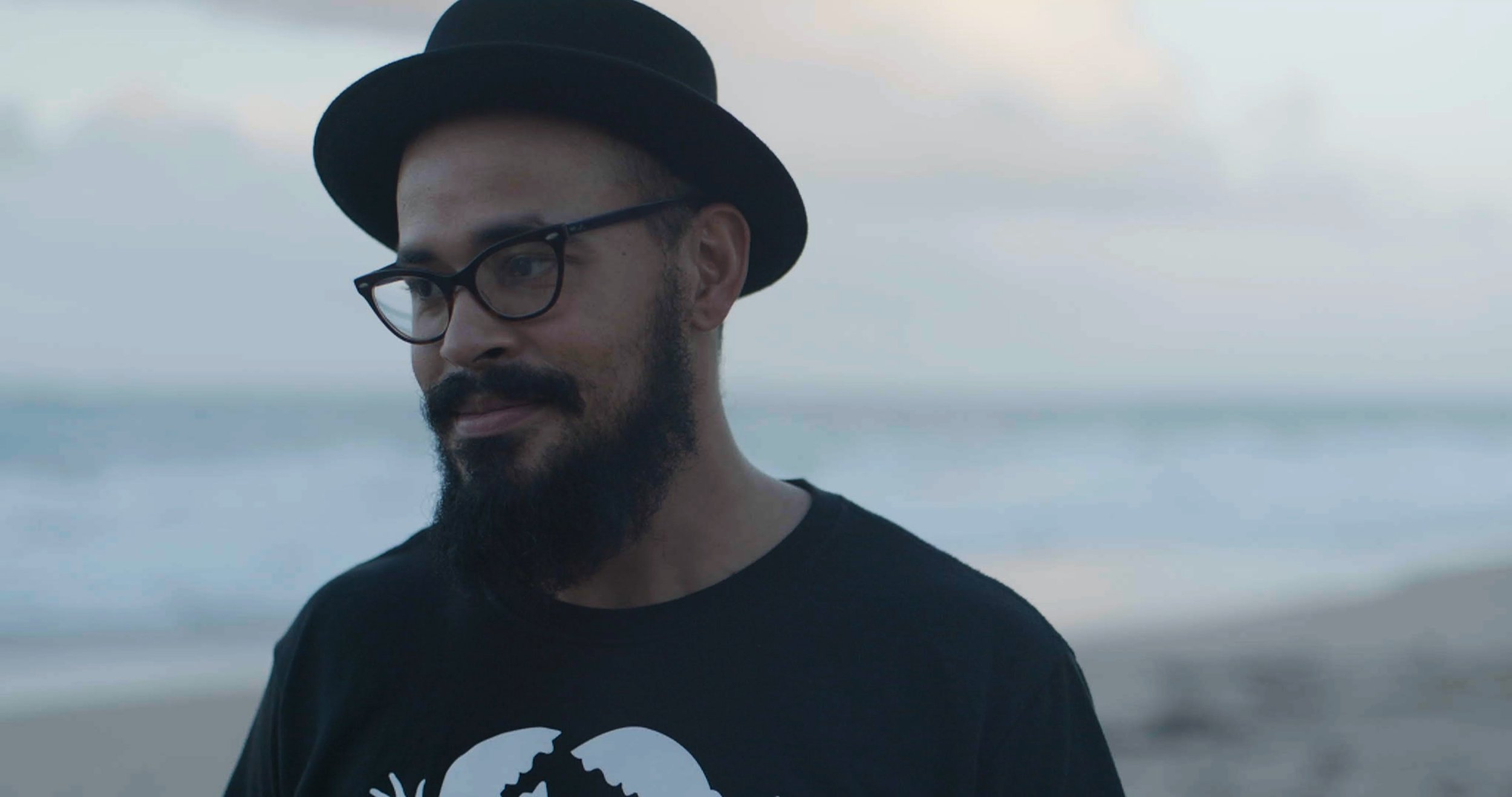 Jody Santalicueva by the ocean in San Juan, Puerto Rico. Still from Hurricane Maria: Stories from the Storm, directed by Sam Menendez and produced by Annie Menendez