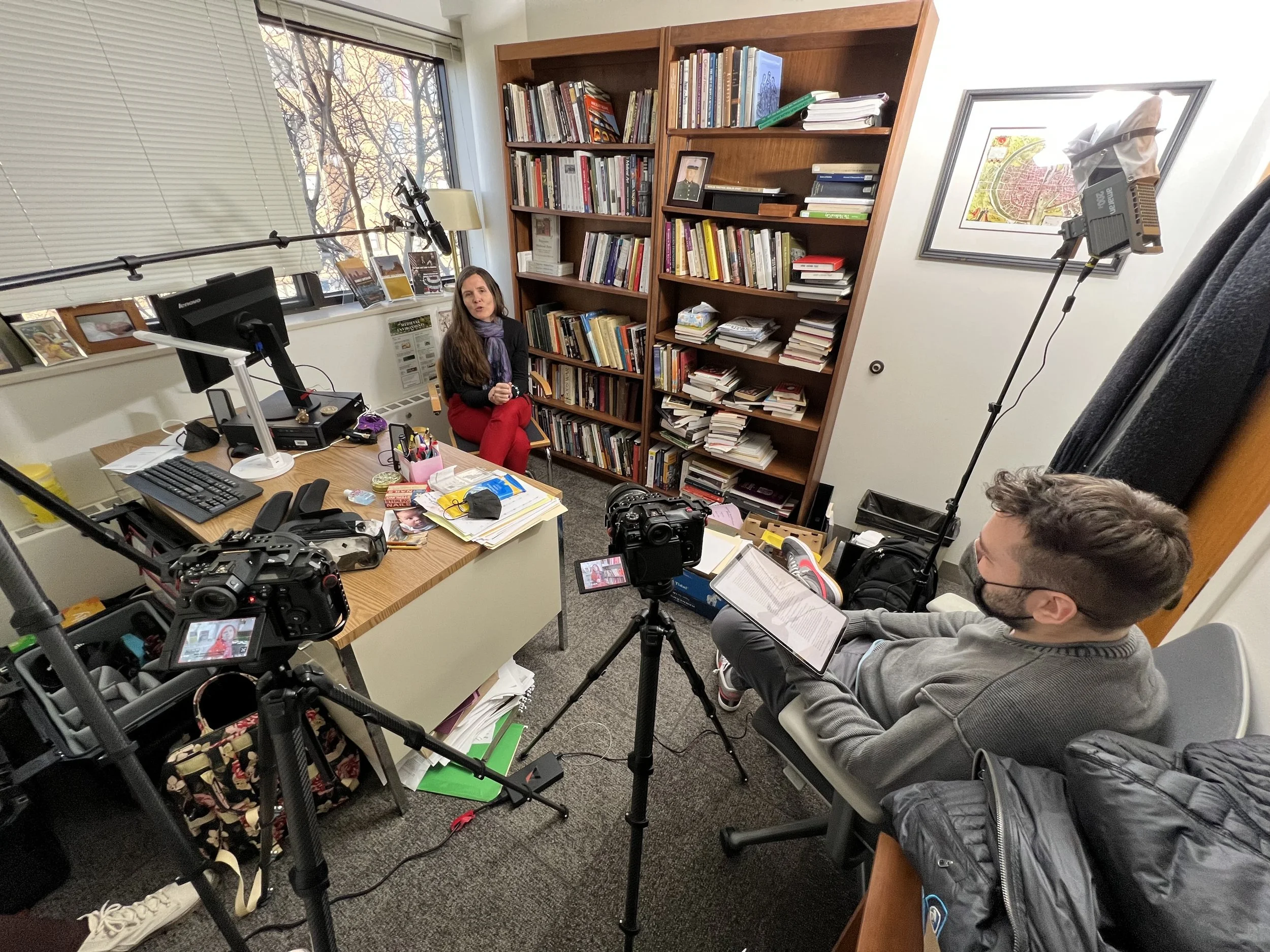 Behind the scenes: crew filming an interview in a home library for The Real Cost, a student debt documentary directed by Sam Menendez and produced by Annie Menendez