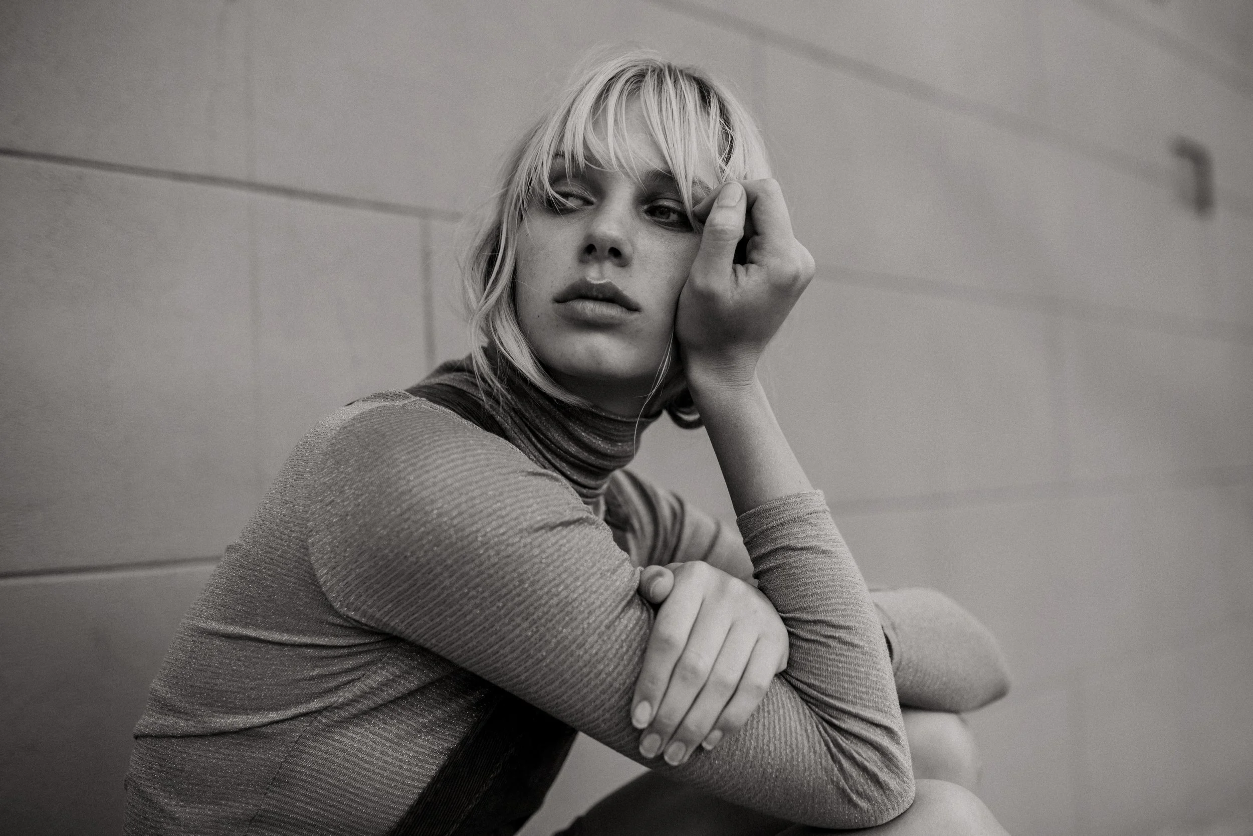 Model crouches and looks seriously into distance.