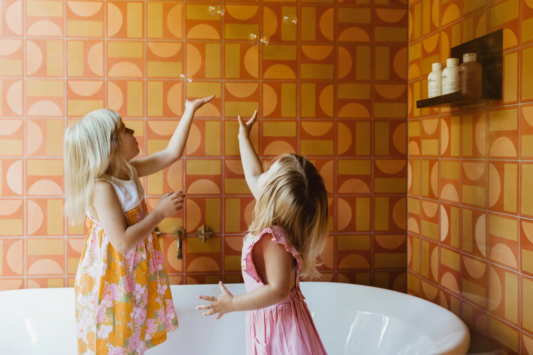 Girls play in bath with bubbles for styled commercial photo shoot in Tasmania.